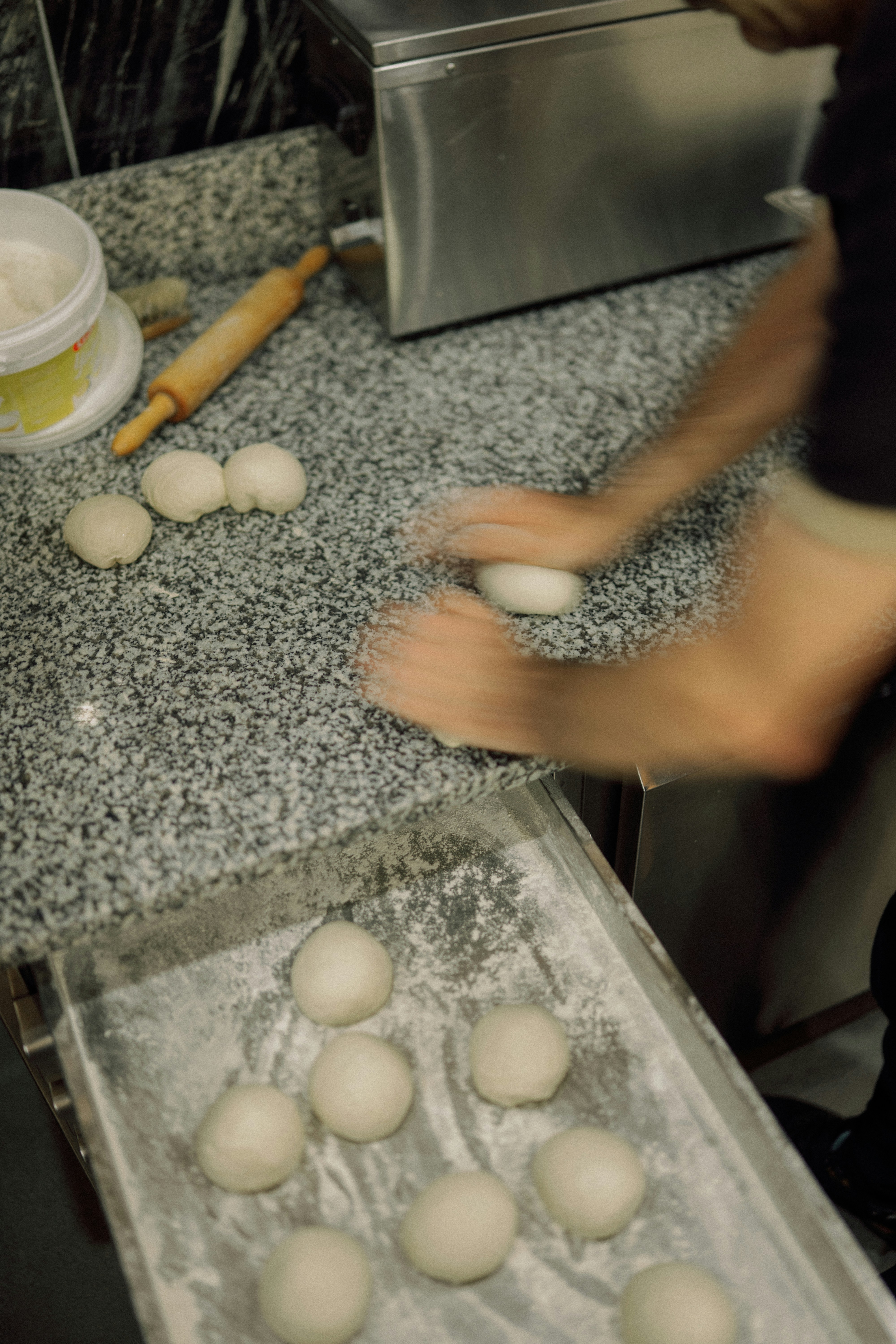 Boulanger façonnant des boules de pâte sur un plan de travail
