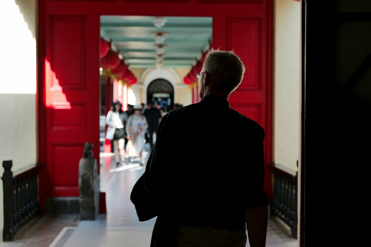 A man walks through a red doorway into a school hall, symbolizing the start of senior spirit week activities.