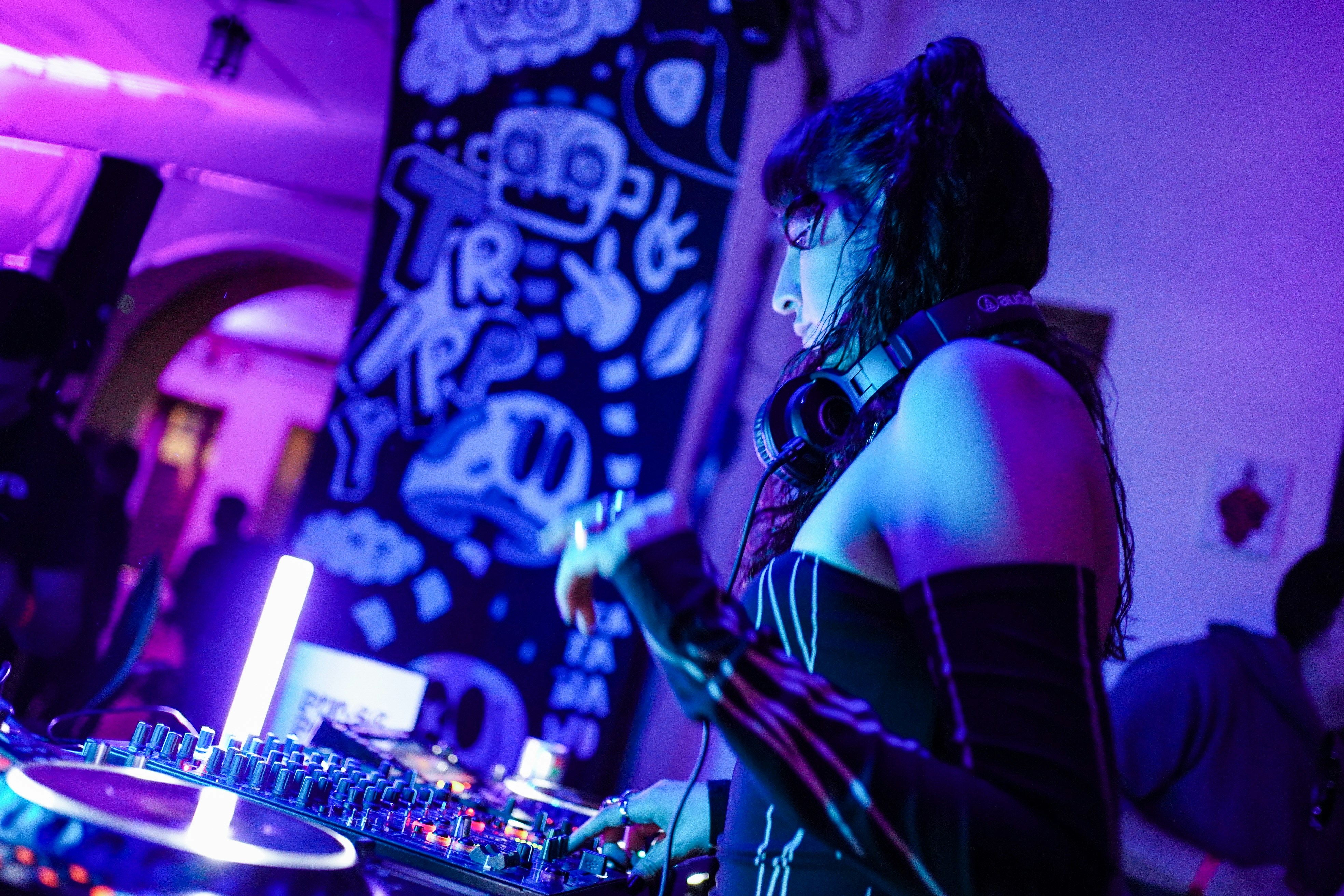 パーティーで女性DJがターンテーブルで音楽をかけています。