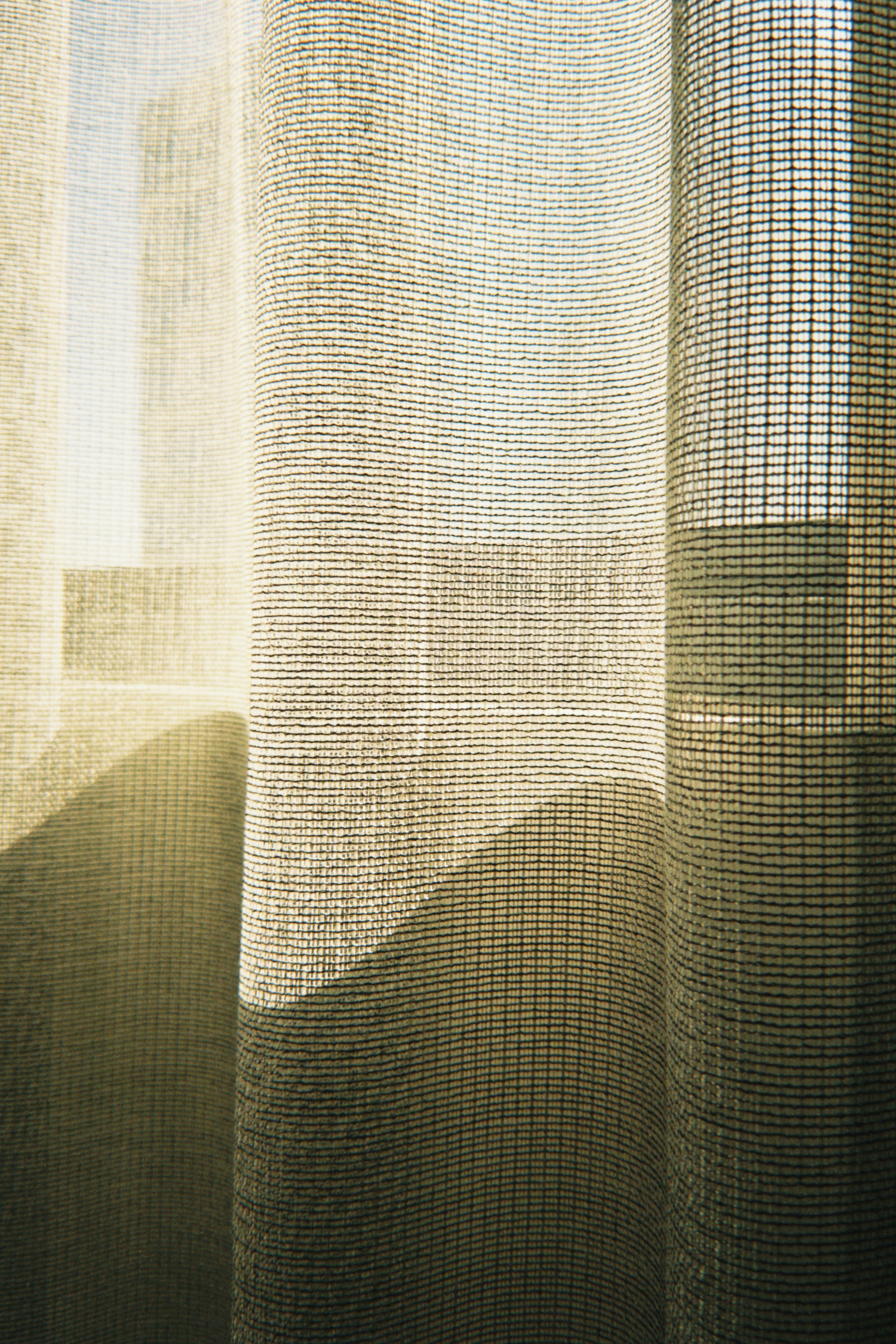Sheer curtains with sunlight casting shadows