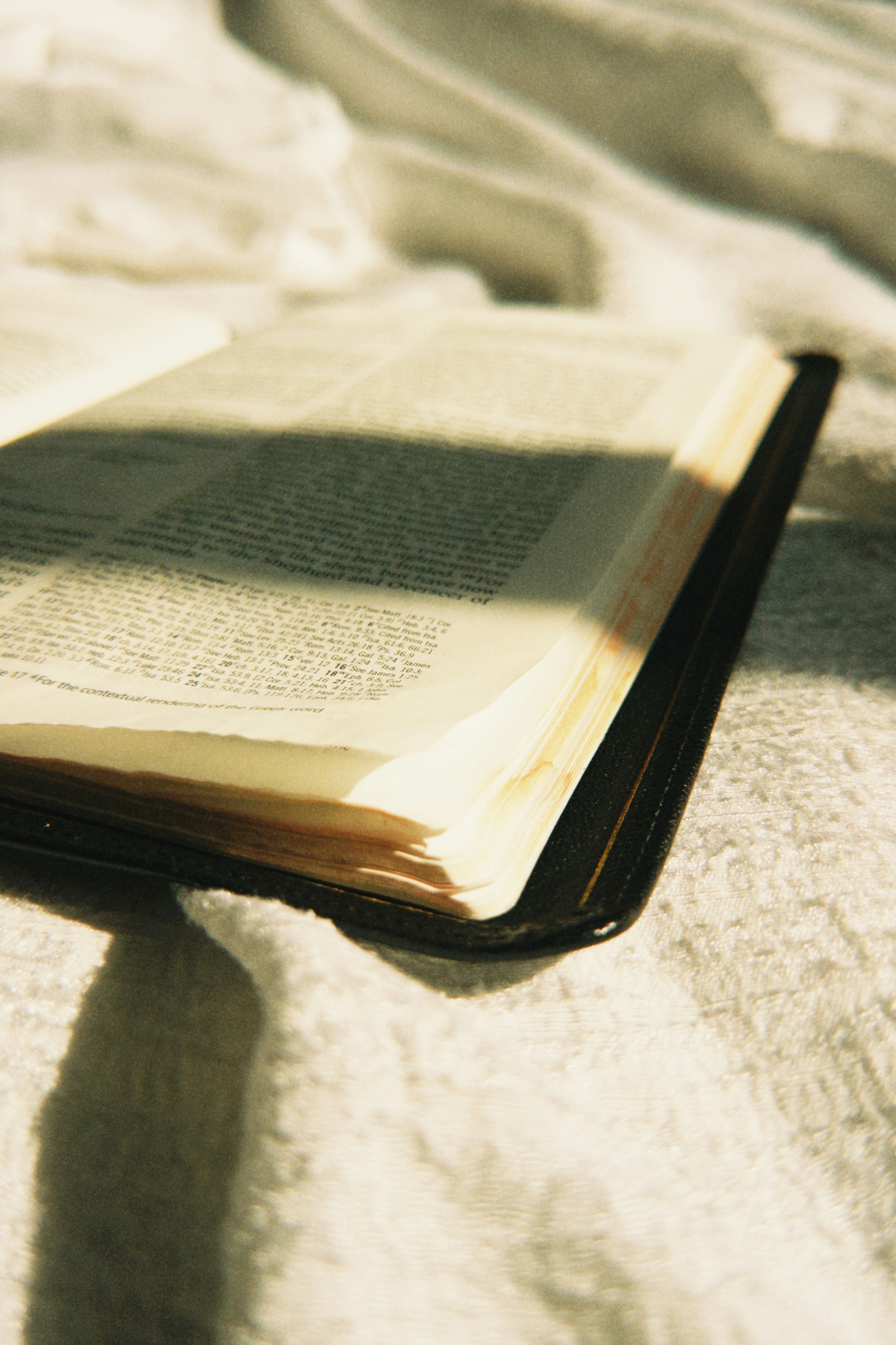 An open book rests on a white textured surface.