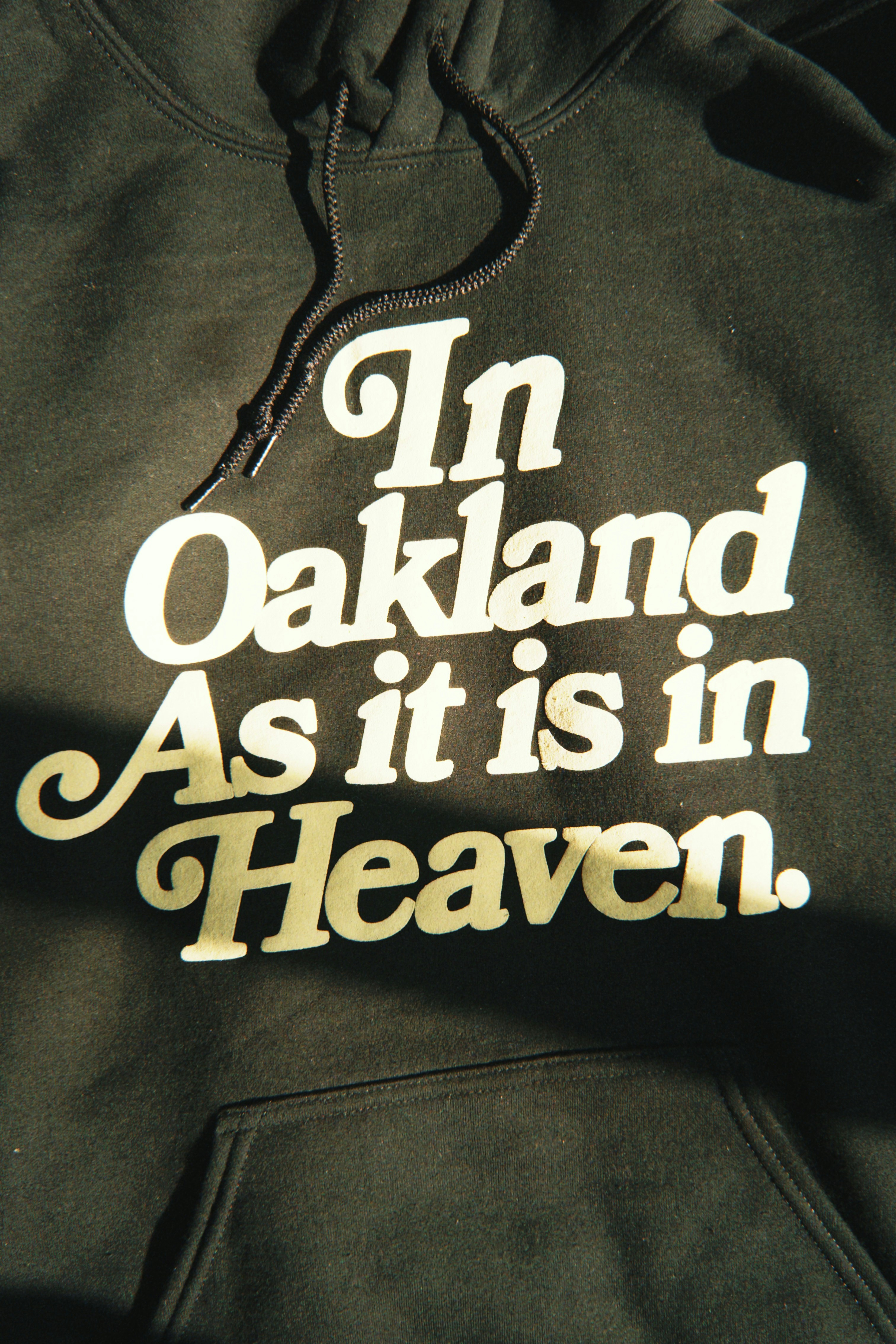 Black hoodie with "in oakland as it is in heaven."