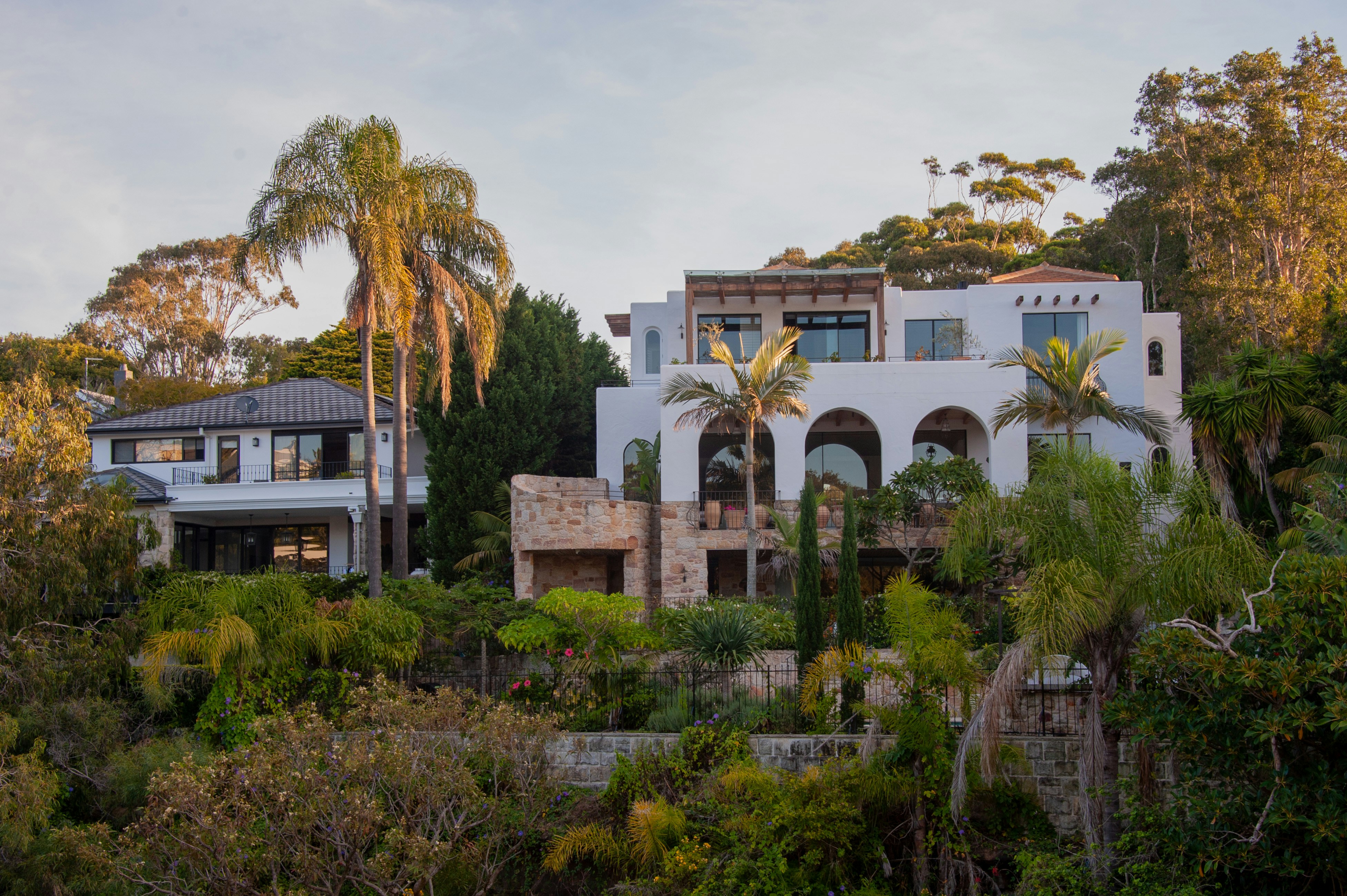 Two luxurious houses nestled on a lush, green hillside.