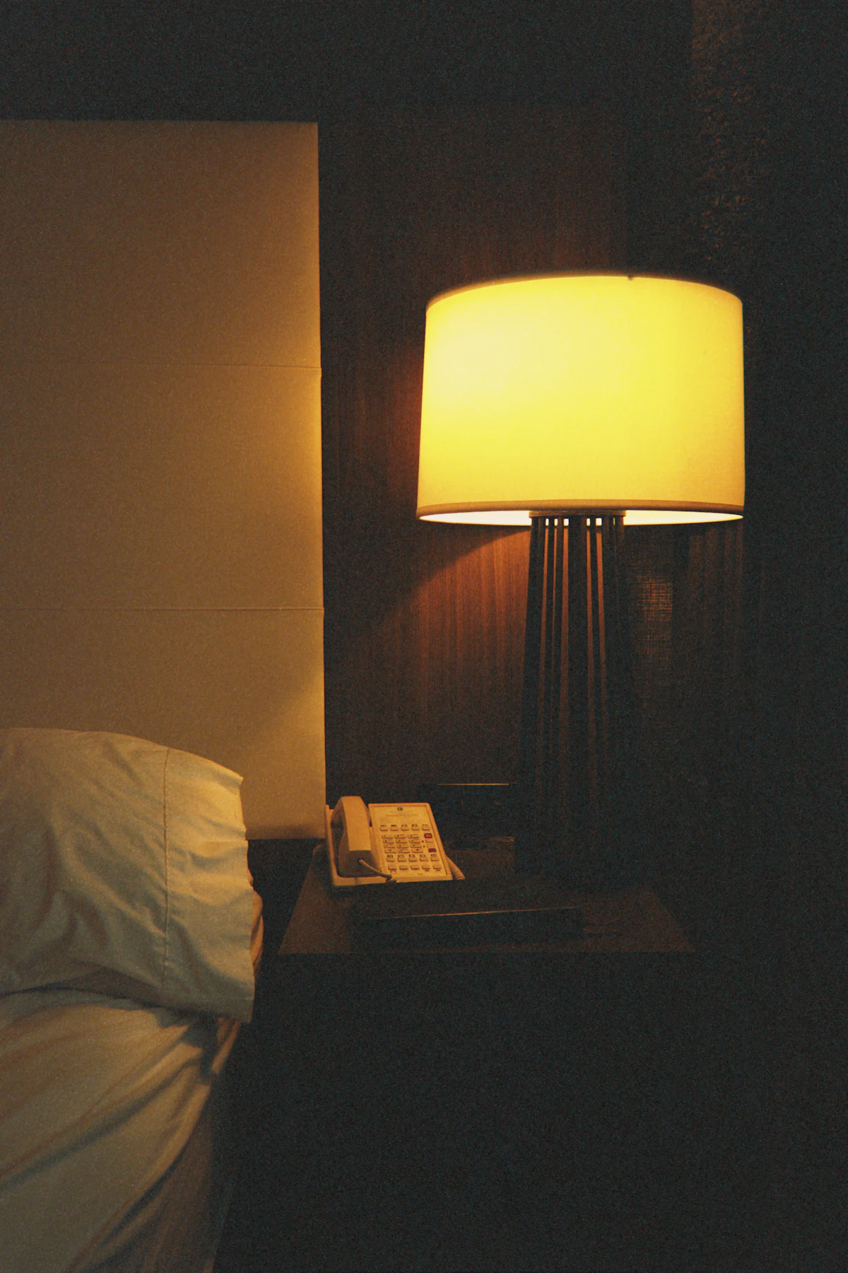 A phone resting on a nightstand at dusk, quiet light.