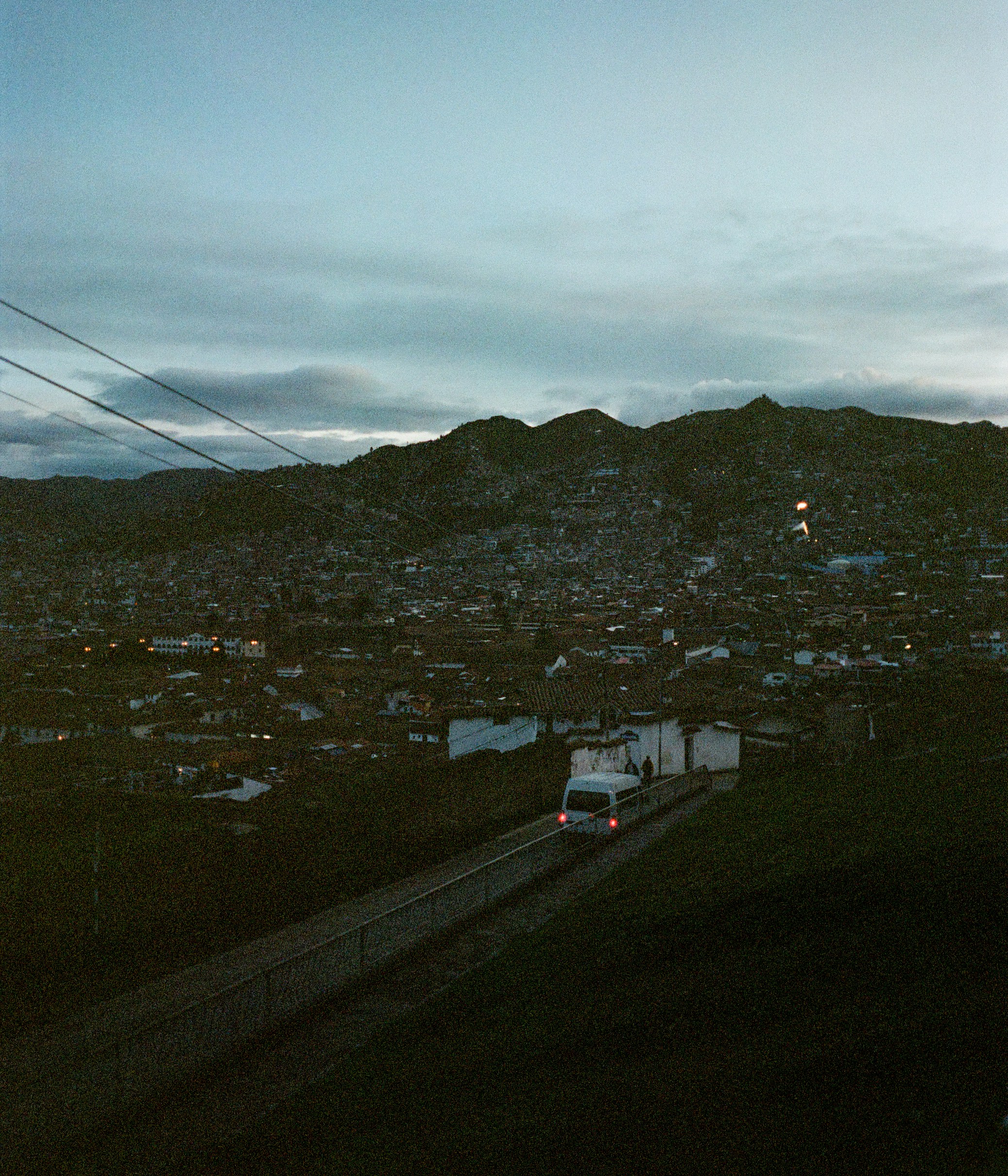 A bus drives on a road with mountains behind