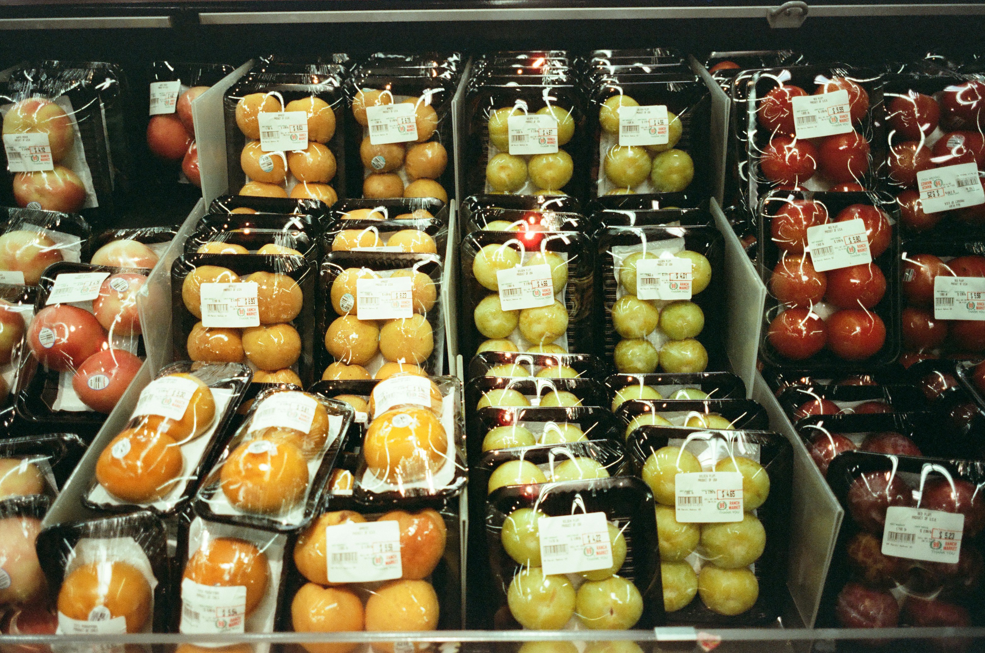 Packaged fruits and vegetables displayed in a market.
