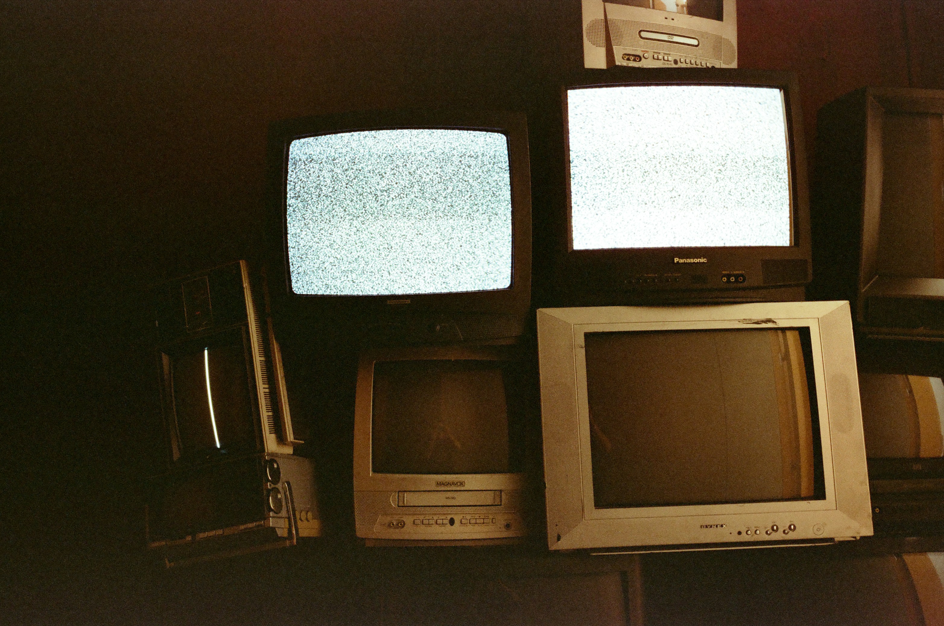 Pilha de televisores antigos exibindo estática