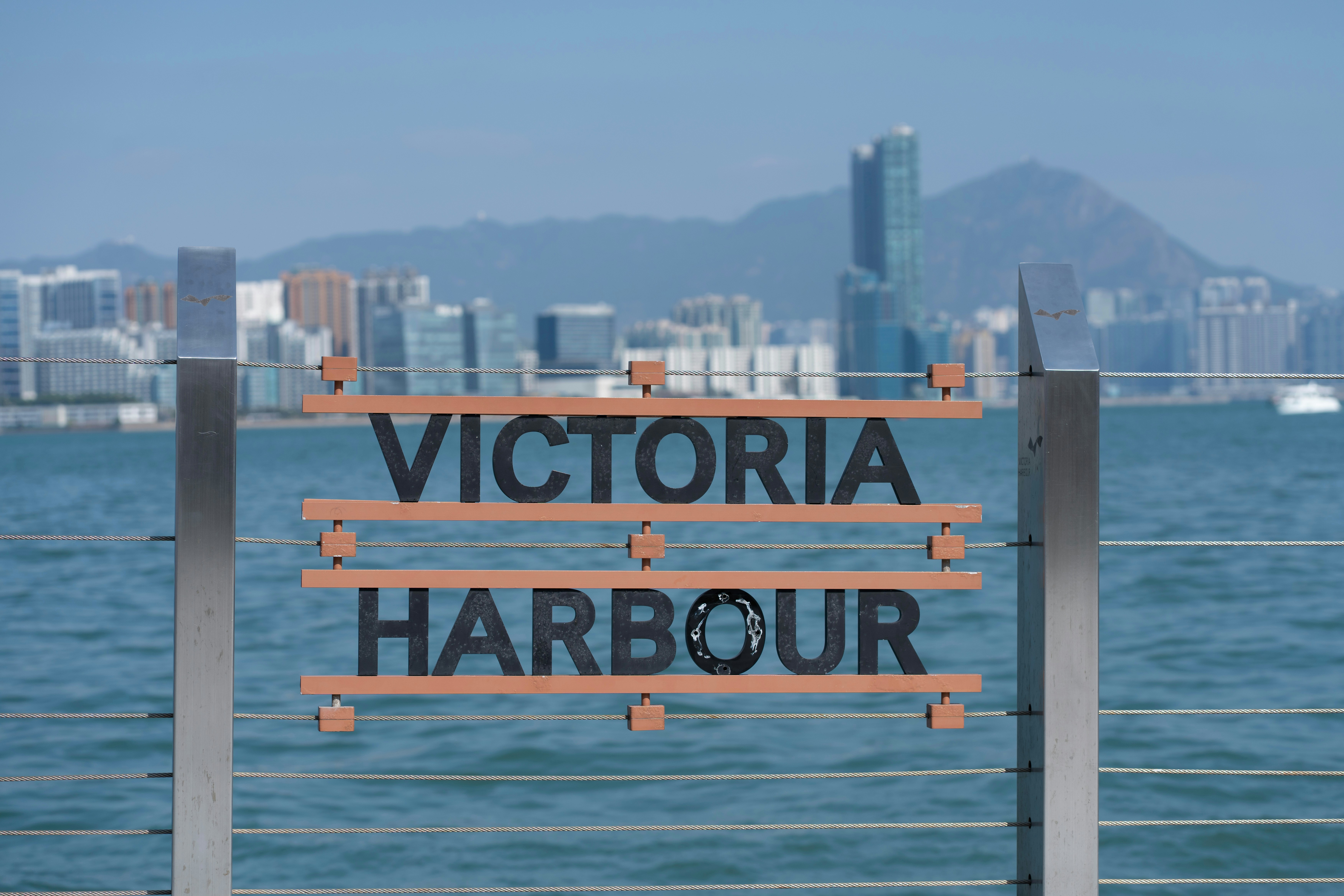 Victoria harbour sign with city skyline background