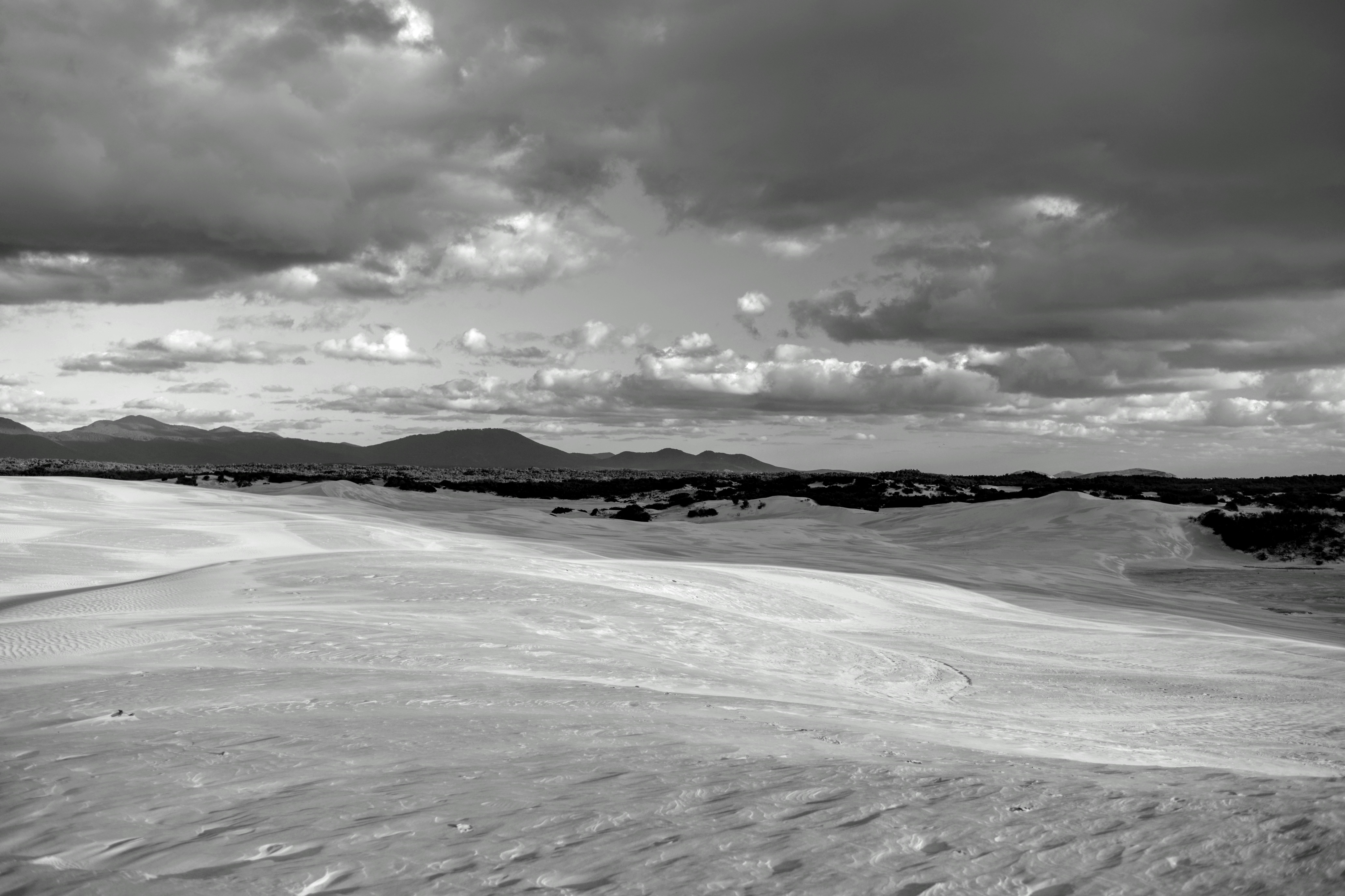Dune di sabbia rotolate sotto un cielo nuvoloso e drammatico