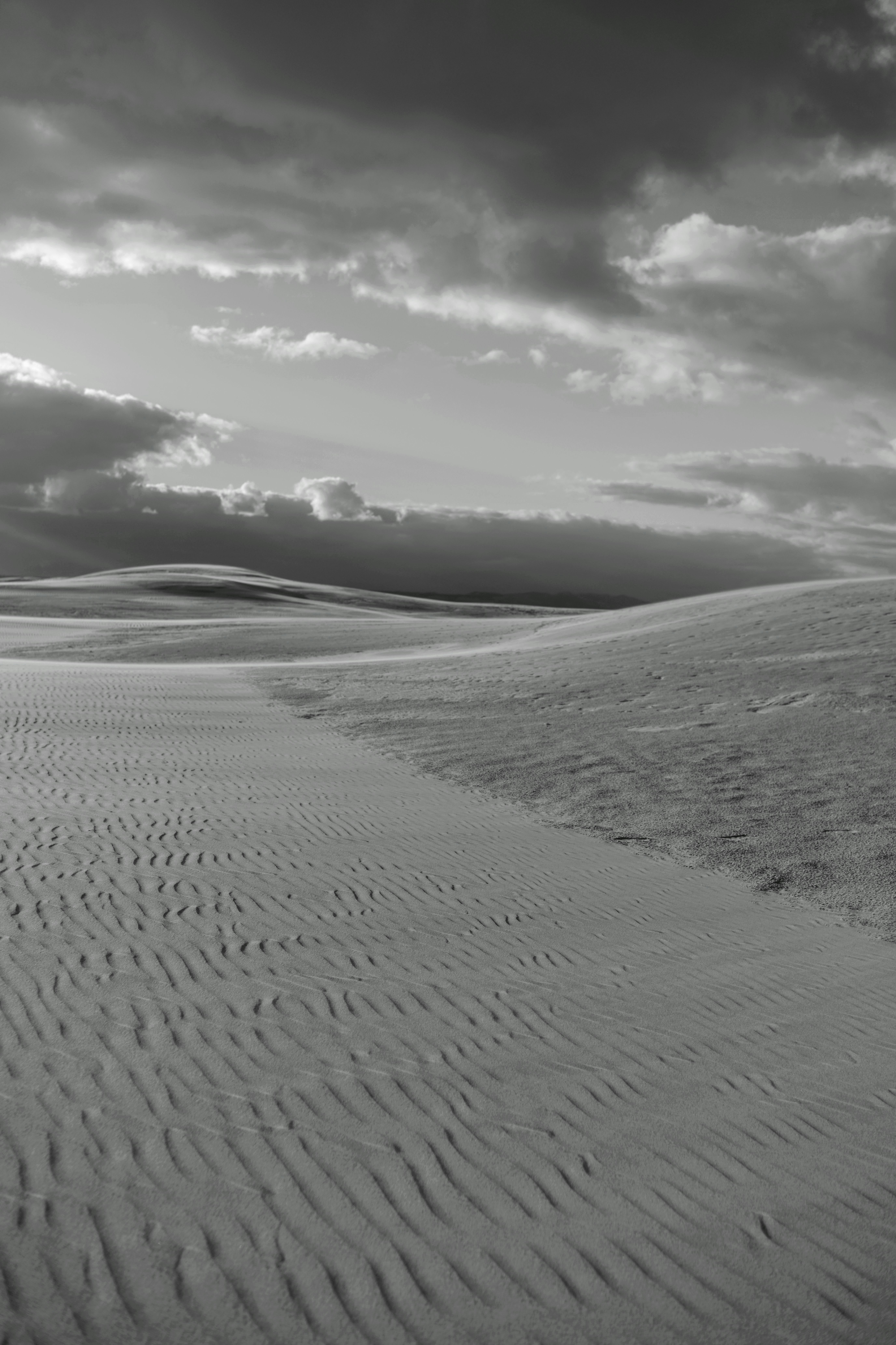 Dune sabbiose sotto un cielo nuvoloso e drammatico