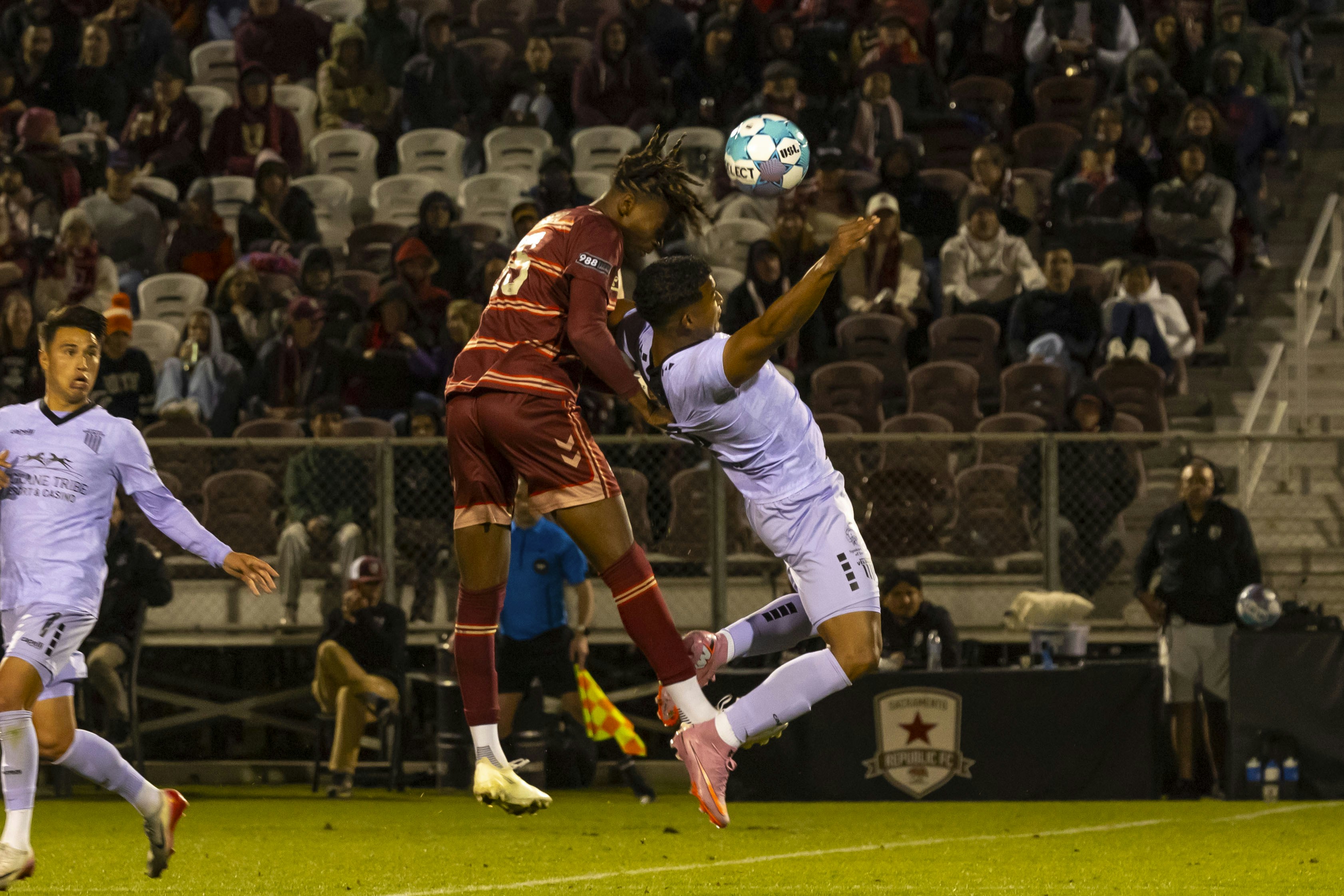 Soccer players jumping to head the ball