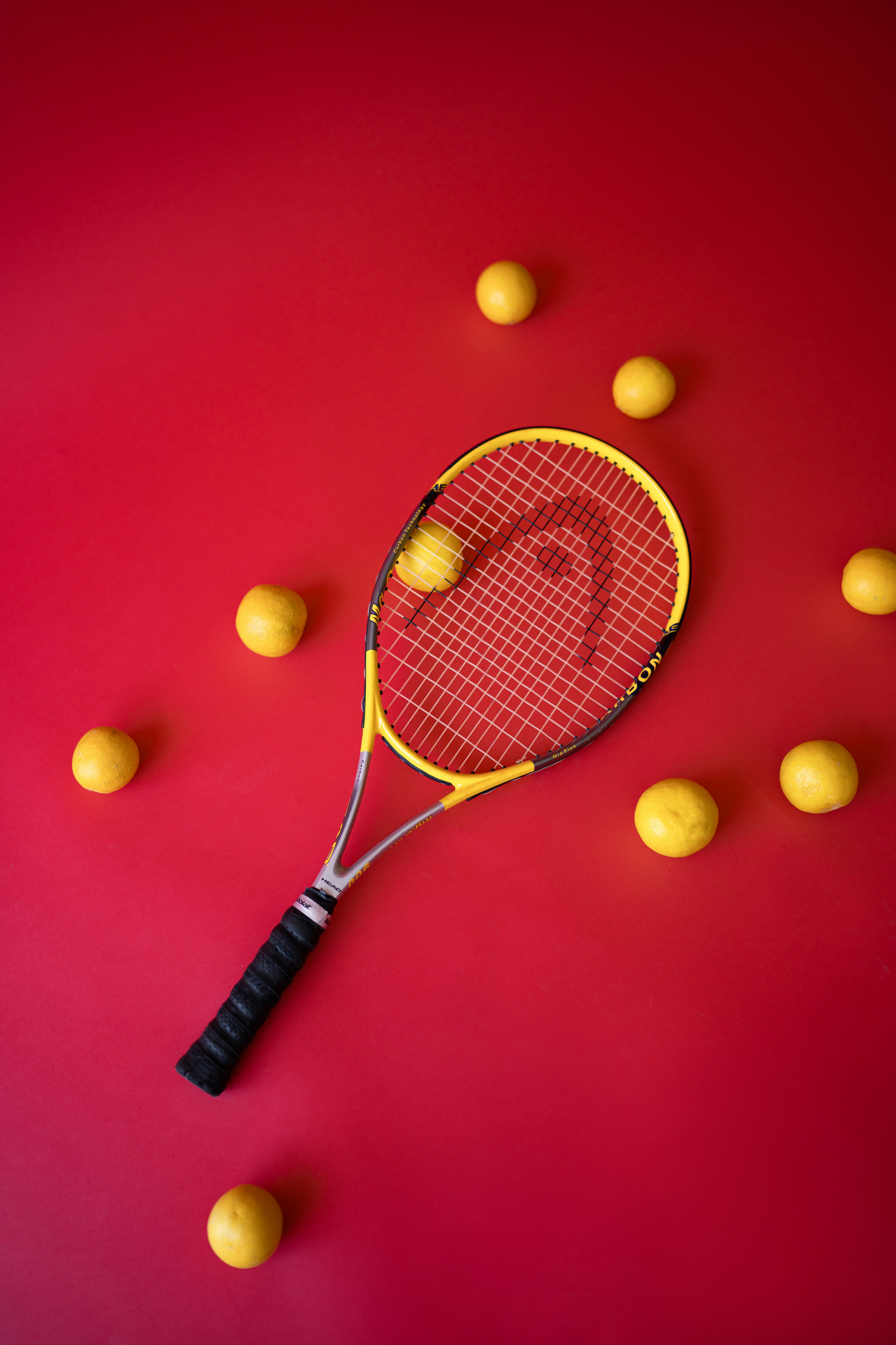 Tennis racket with yellow balls on red background
