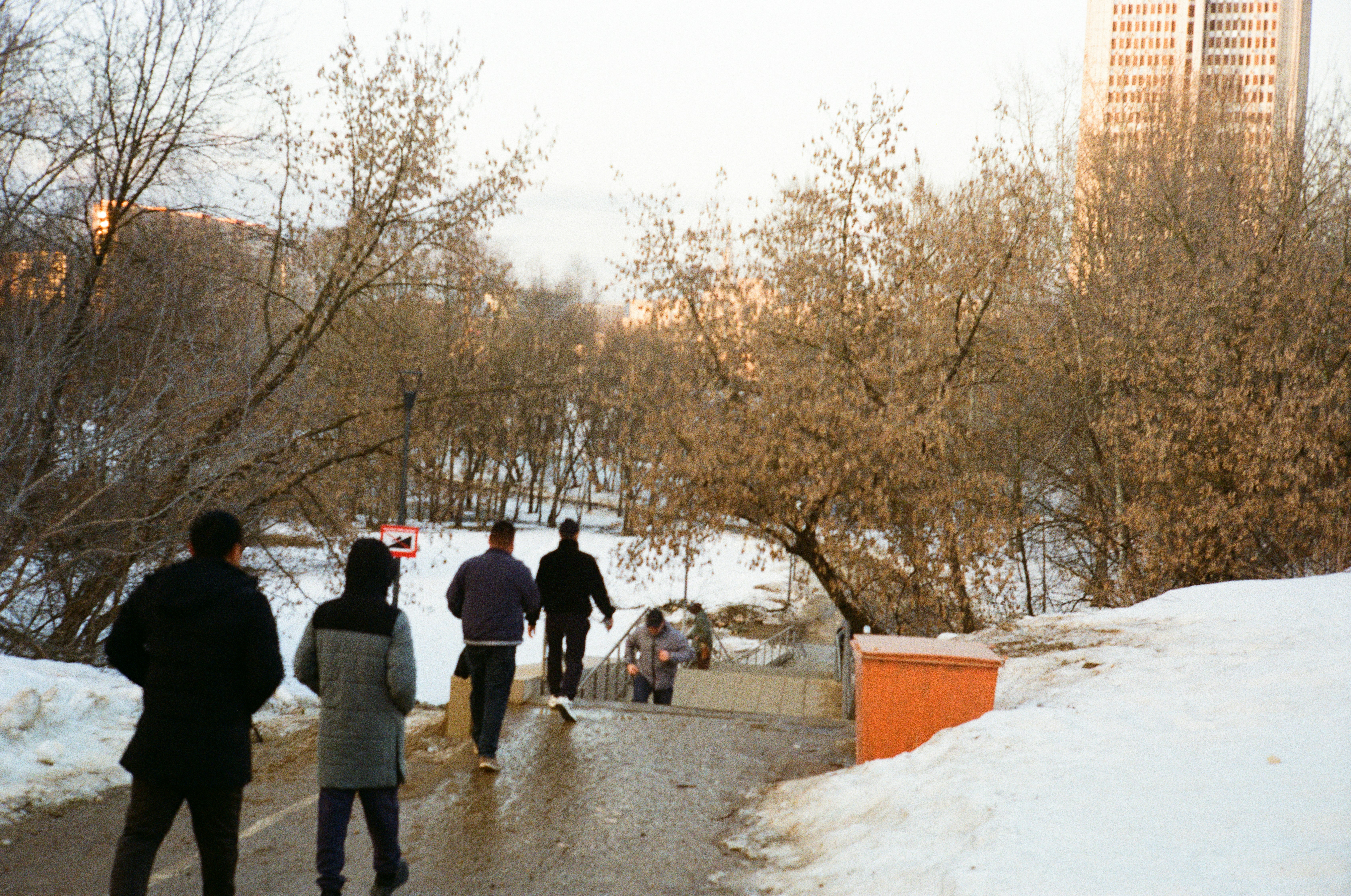 Pessoas caminhando por um caminho nevado perto de árvores