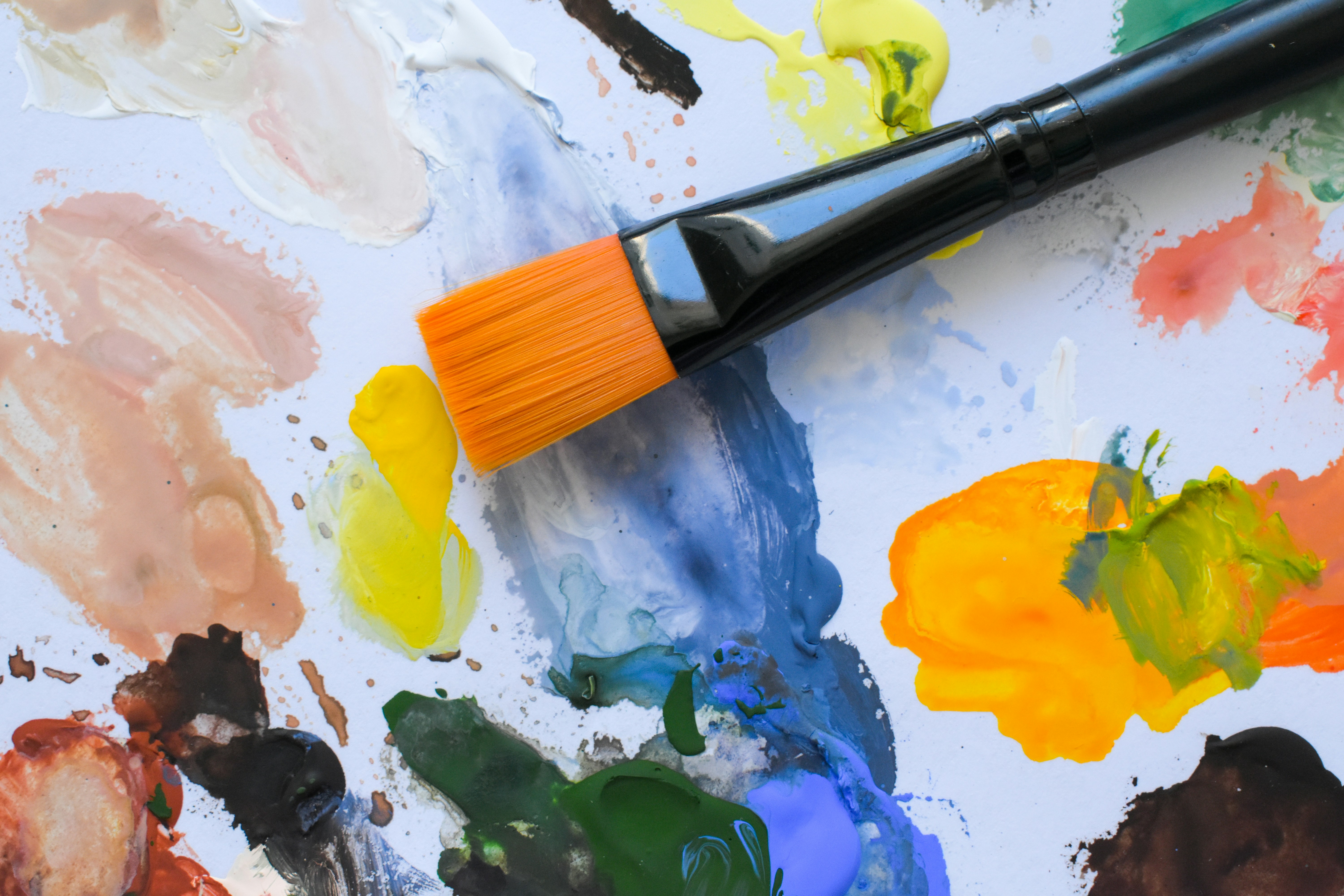 Paintbrush resting on a colorful art palette