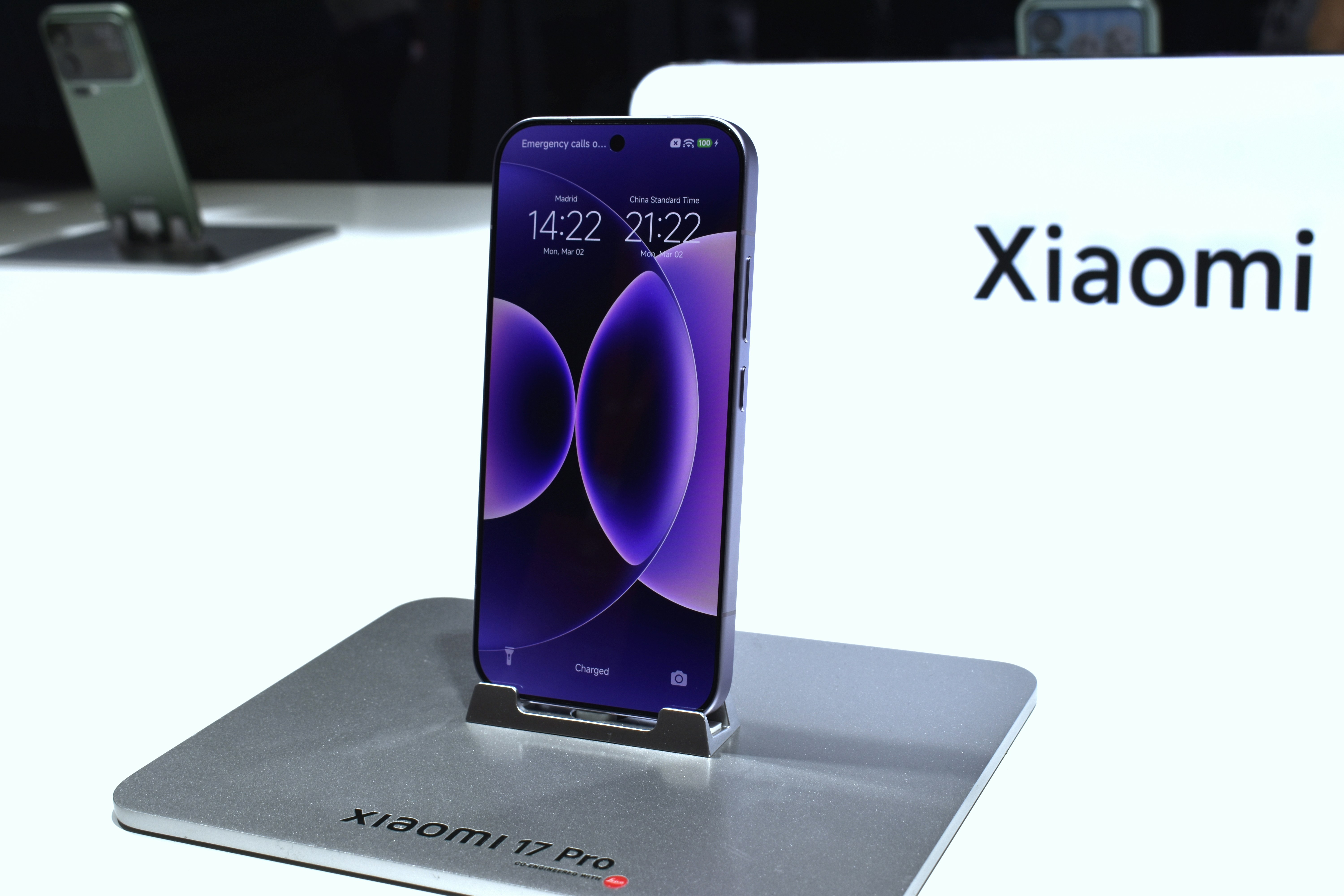 Um smartphone Xiaomi roxo exibido em um suporte.