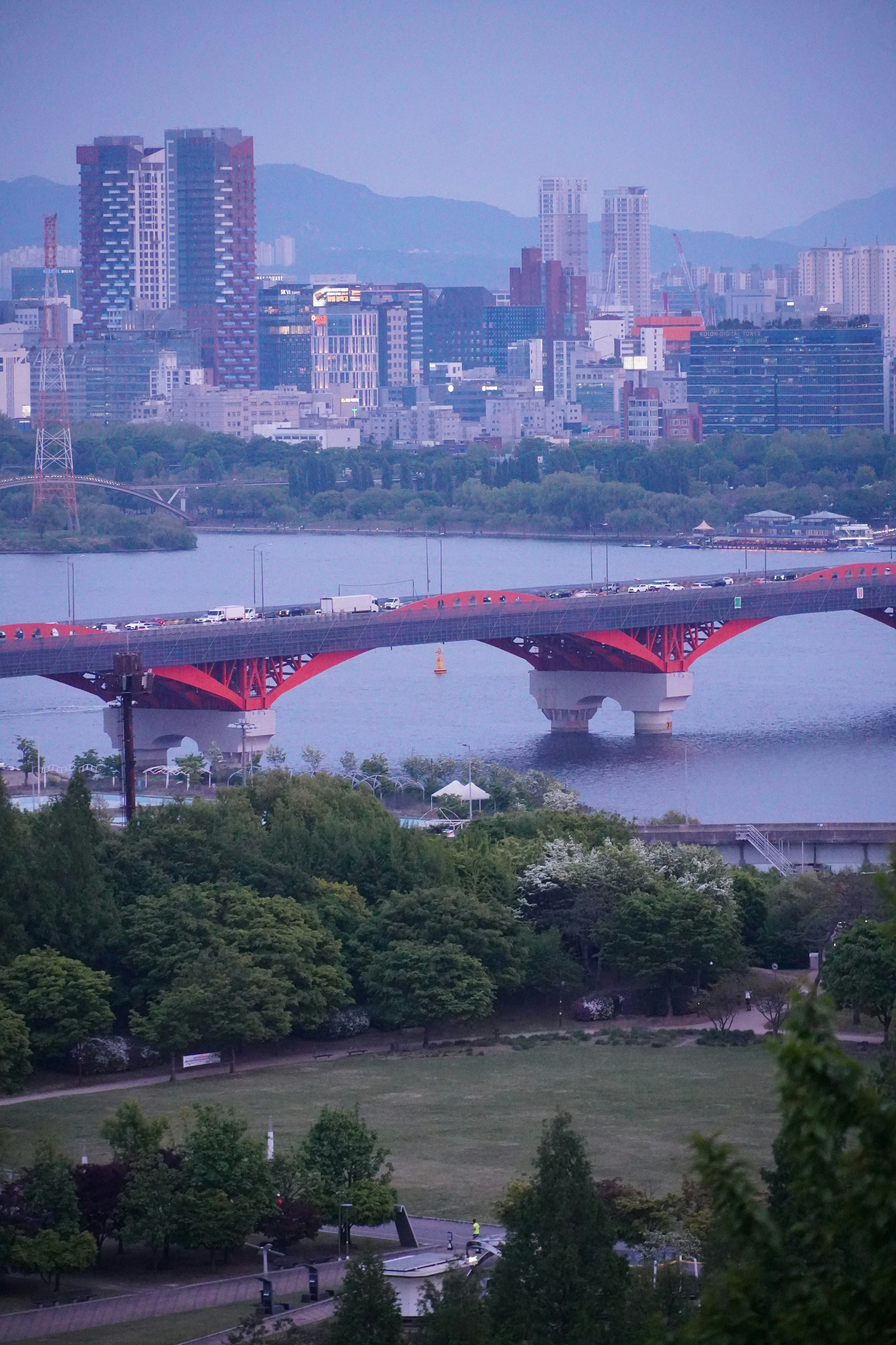 Ponte vermelha sobre o rio com fundo do horizonte da cidade