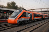 An orange and grey train speeds down the tracks
