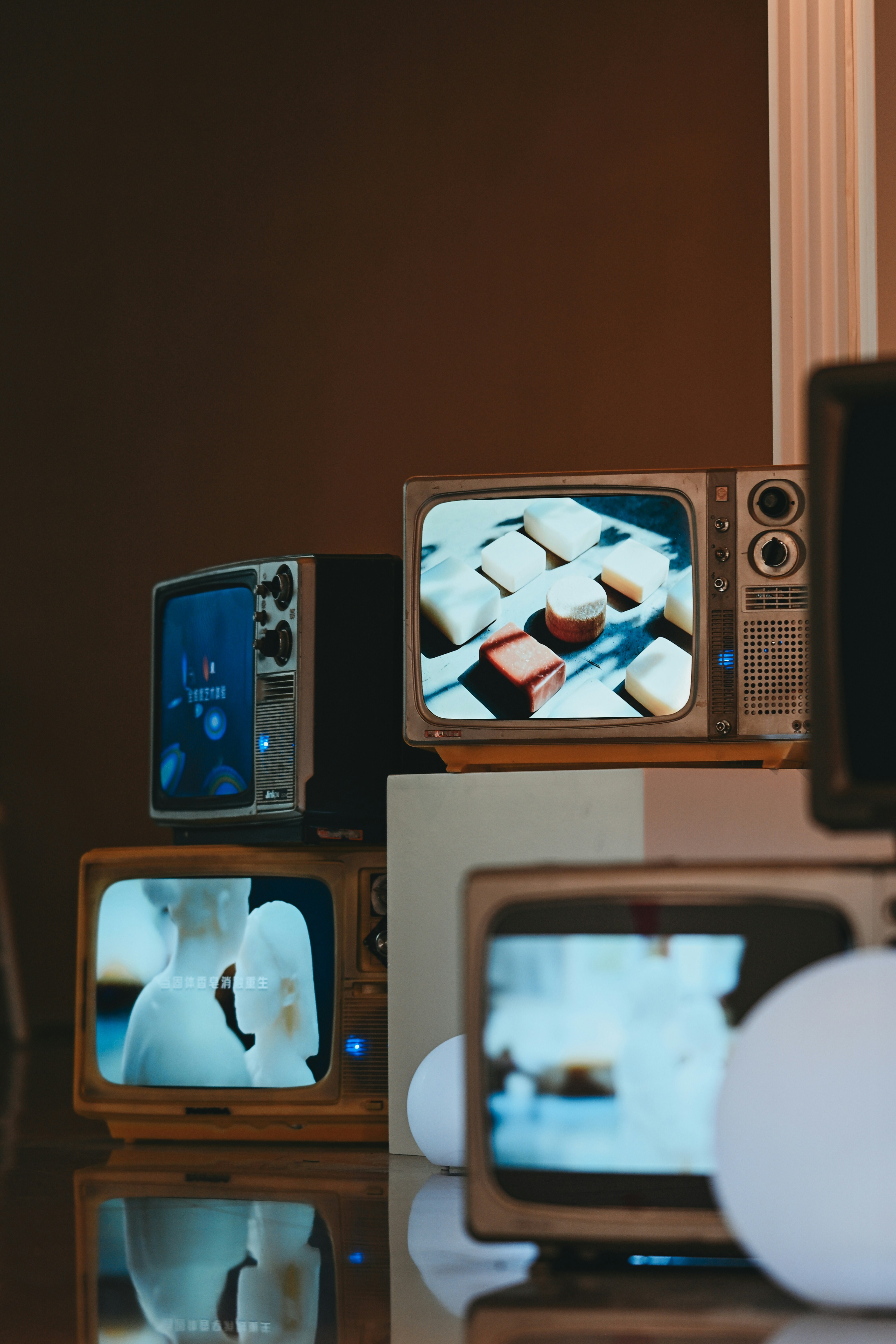 Several vintage televisions displaying various content.
