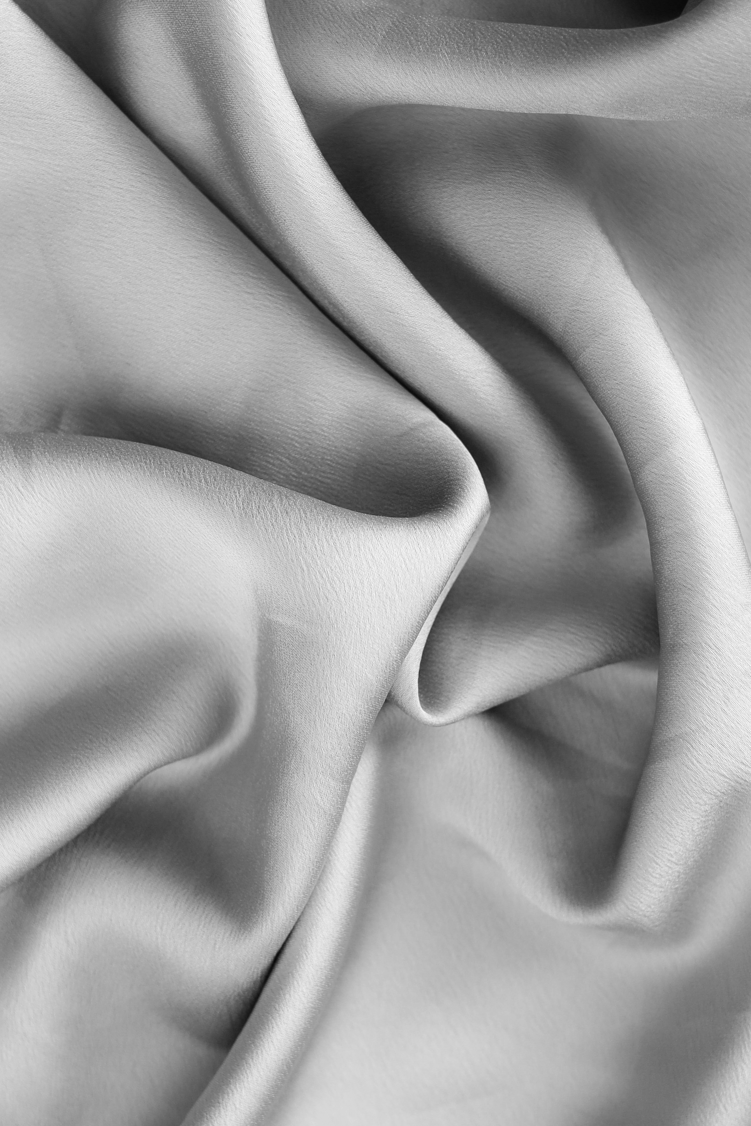 Flowing silver fabric with soft folds and highlights.