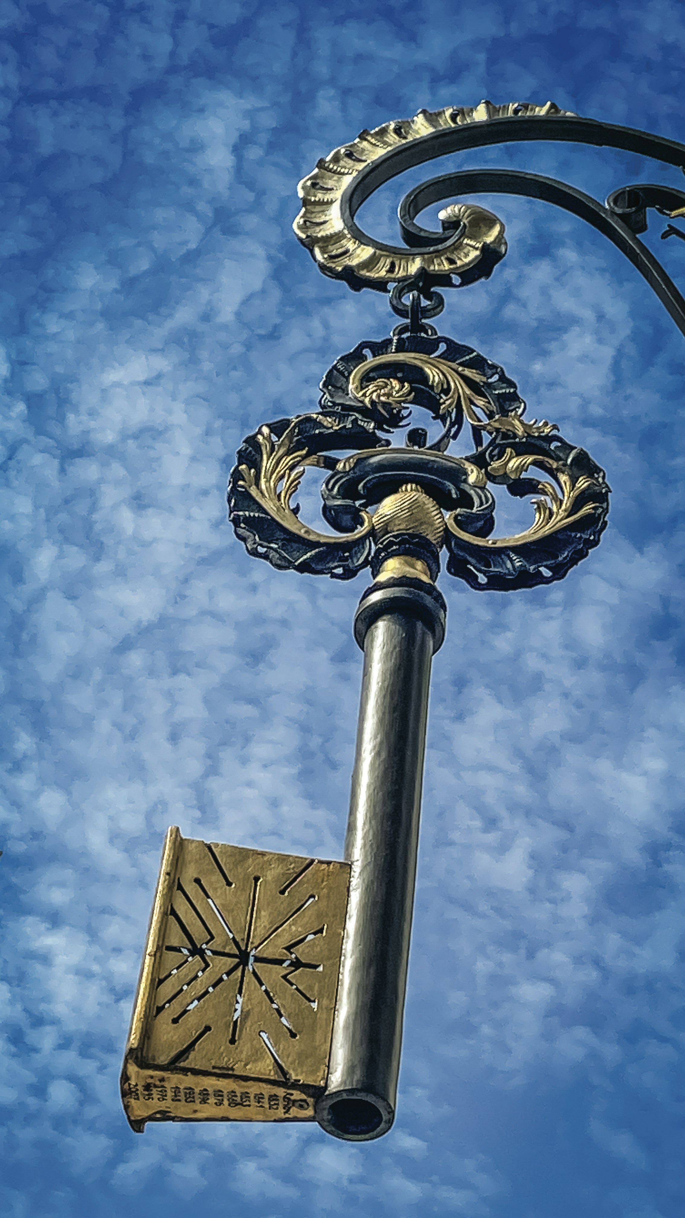 Chave antiga ornamentada pendurada contra um céu azul