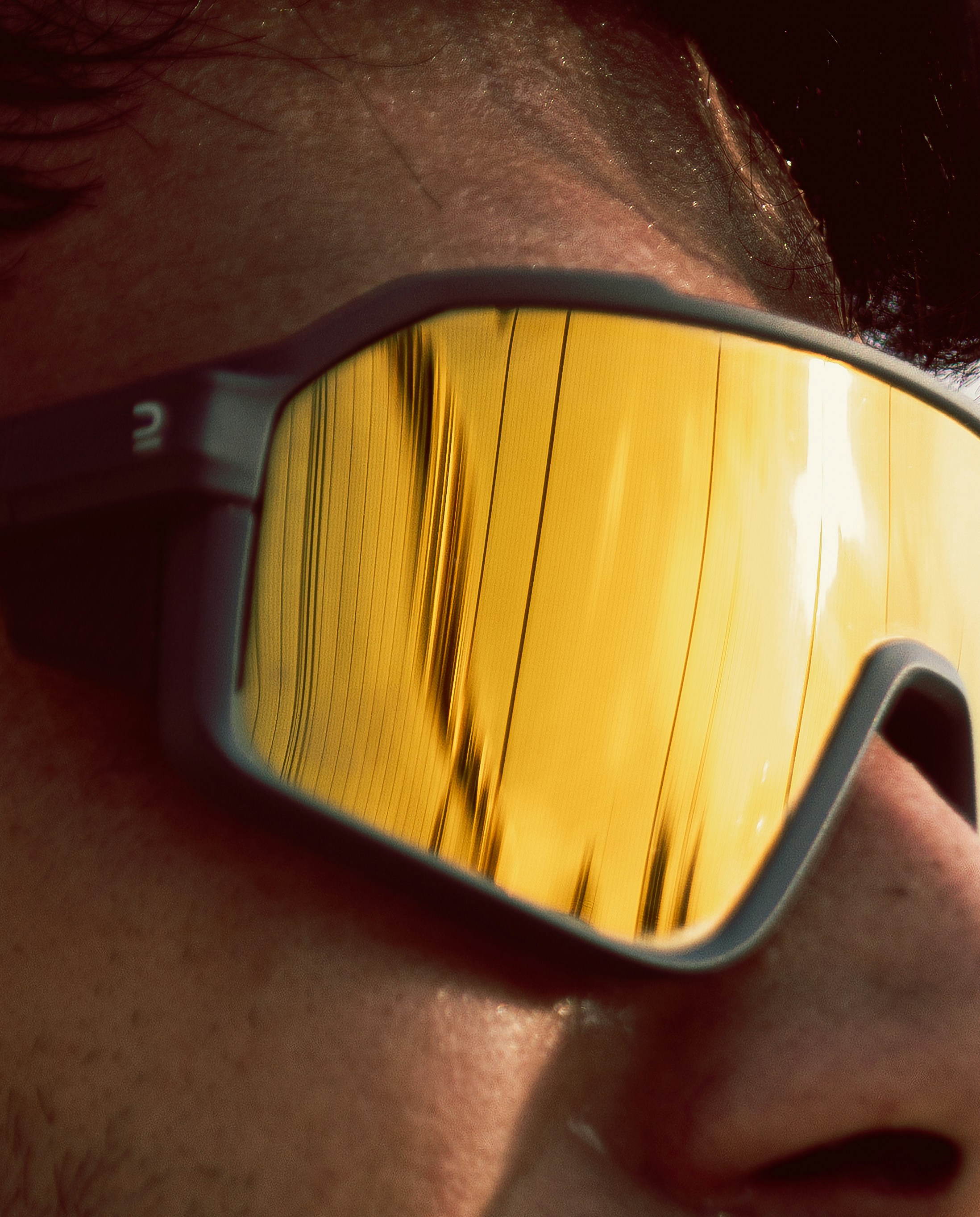 Close-up of a person wearing yellow mirrored sunglasses