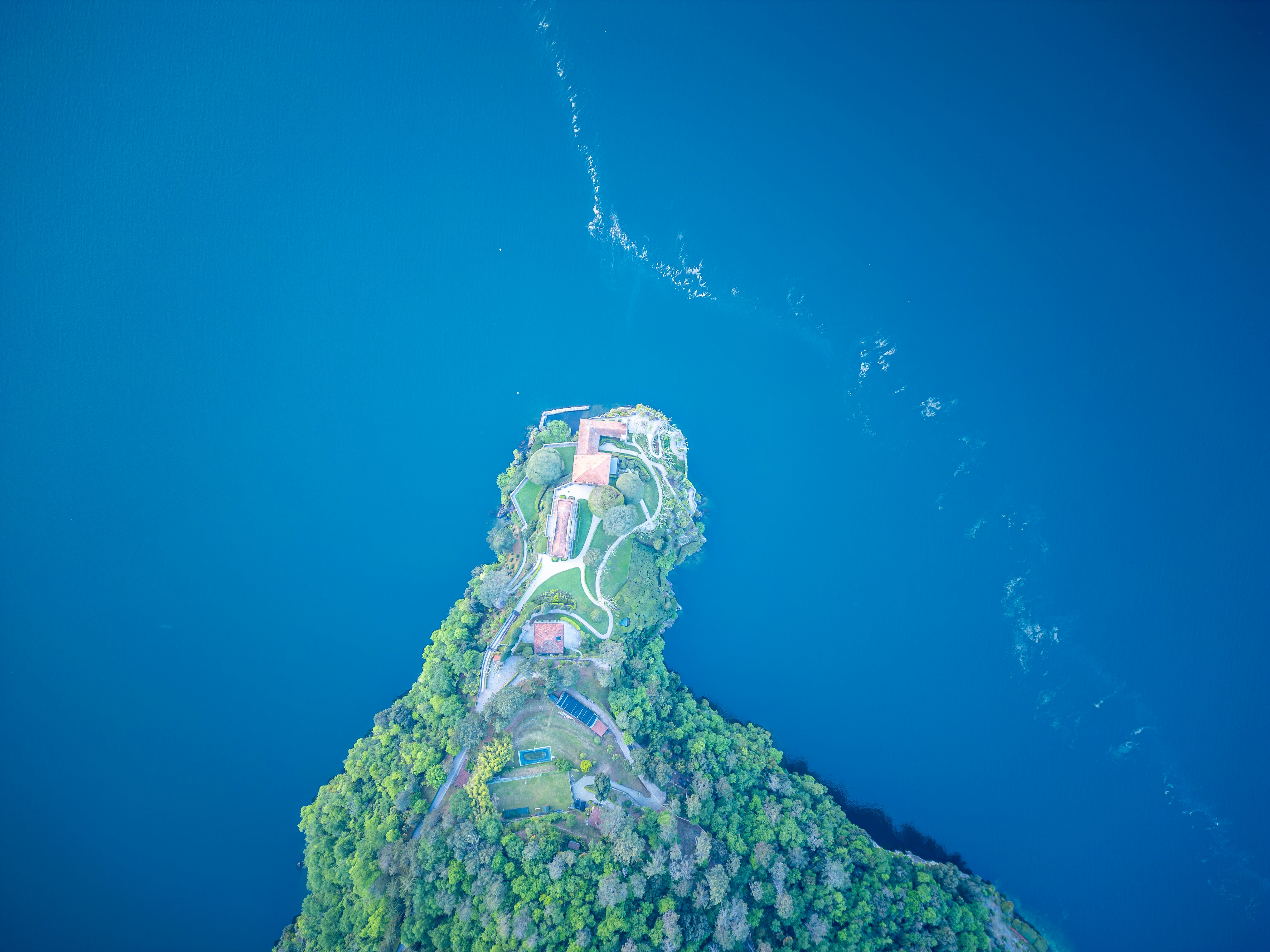Aerial view of a lush green island in blue water.
