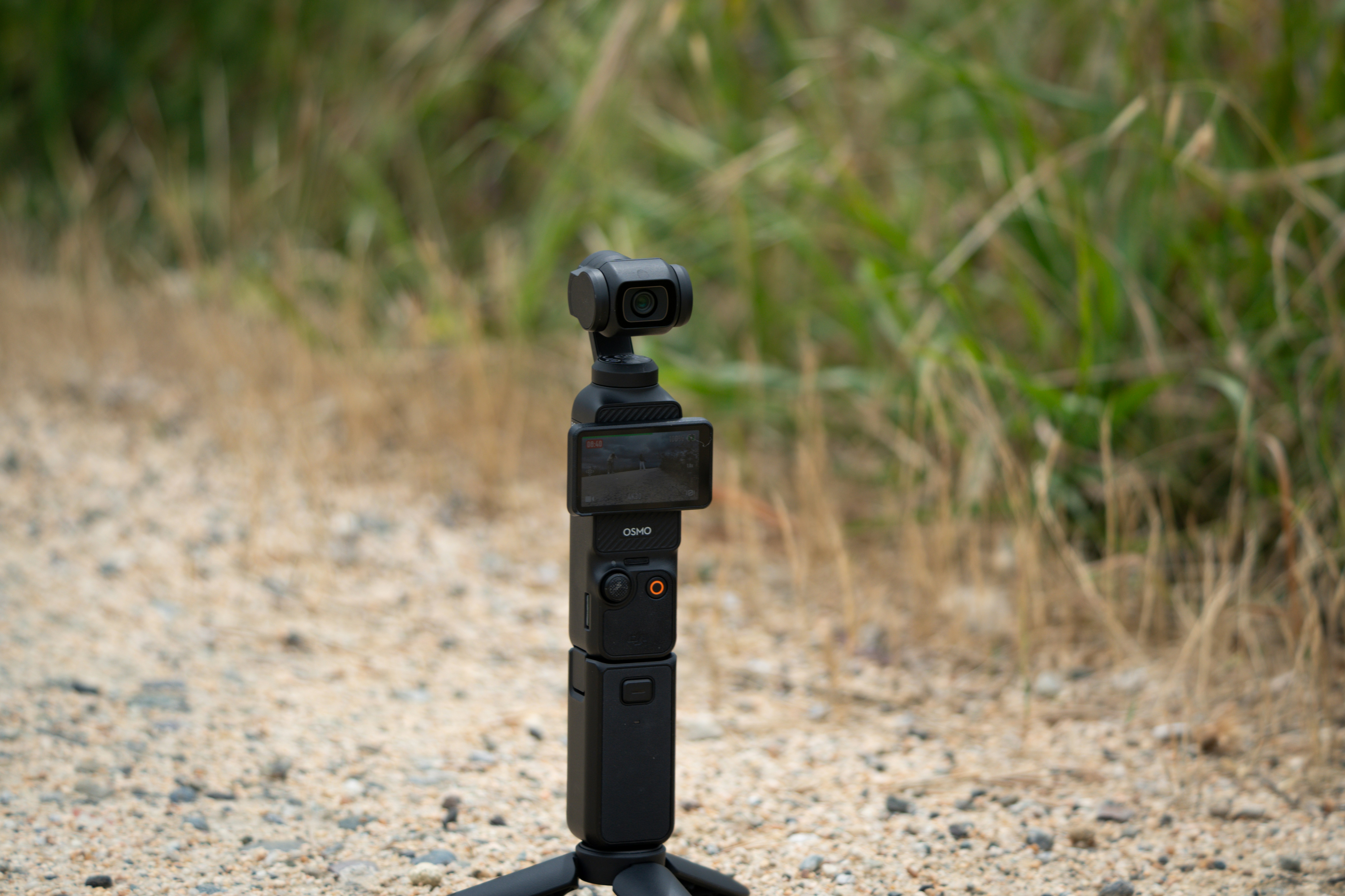 A black gimbal stabilizer with camera outdoors.