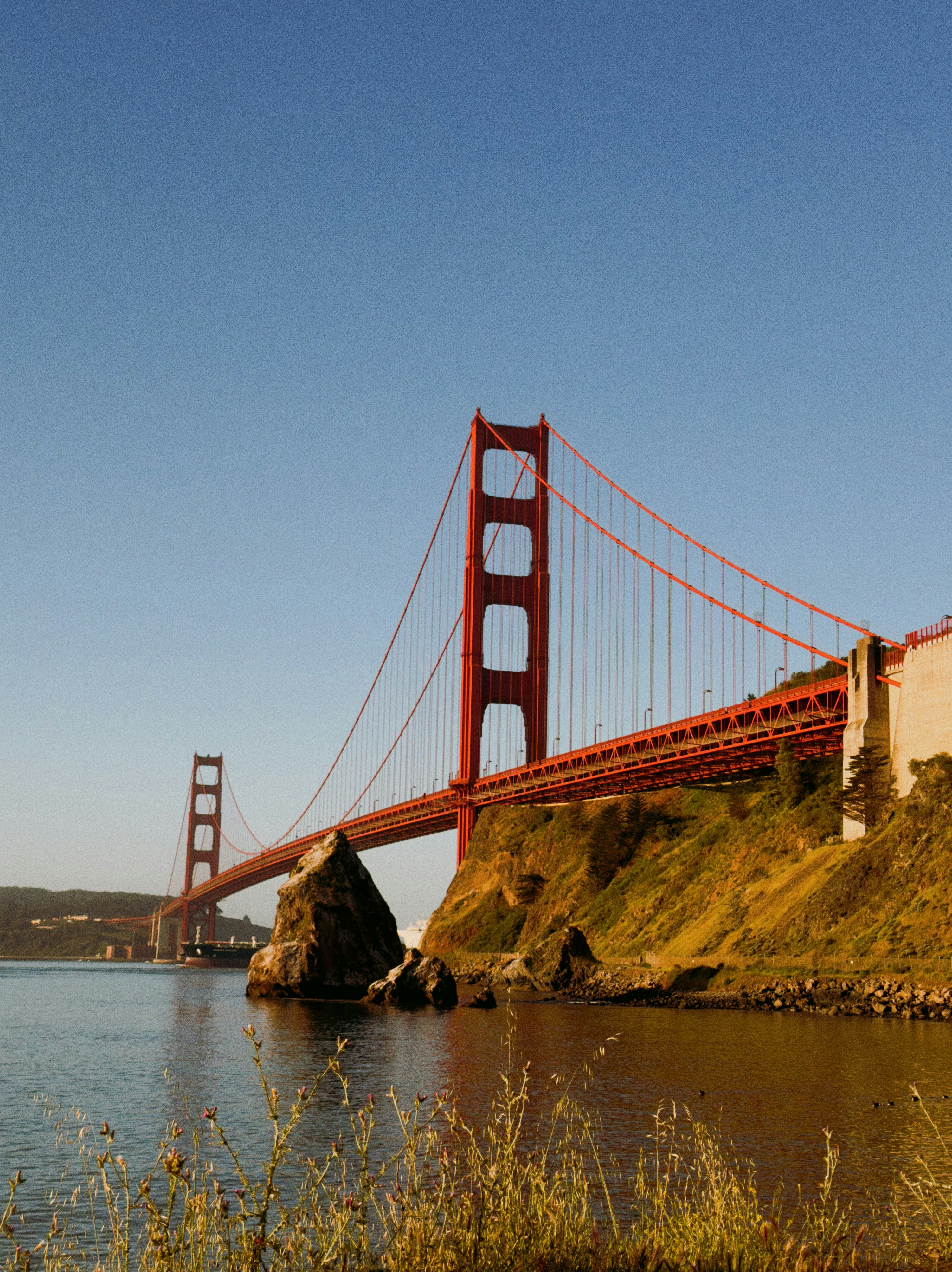 The golden gate bridge spans across the water.