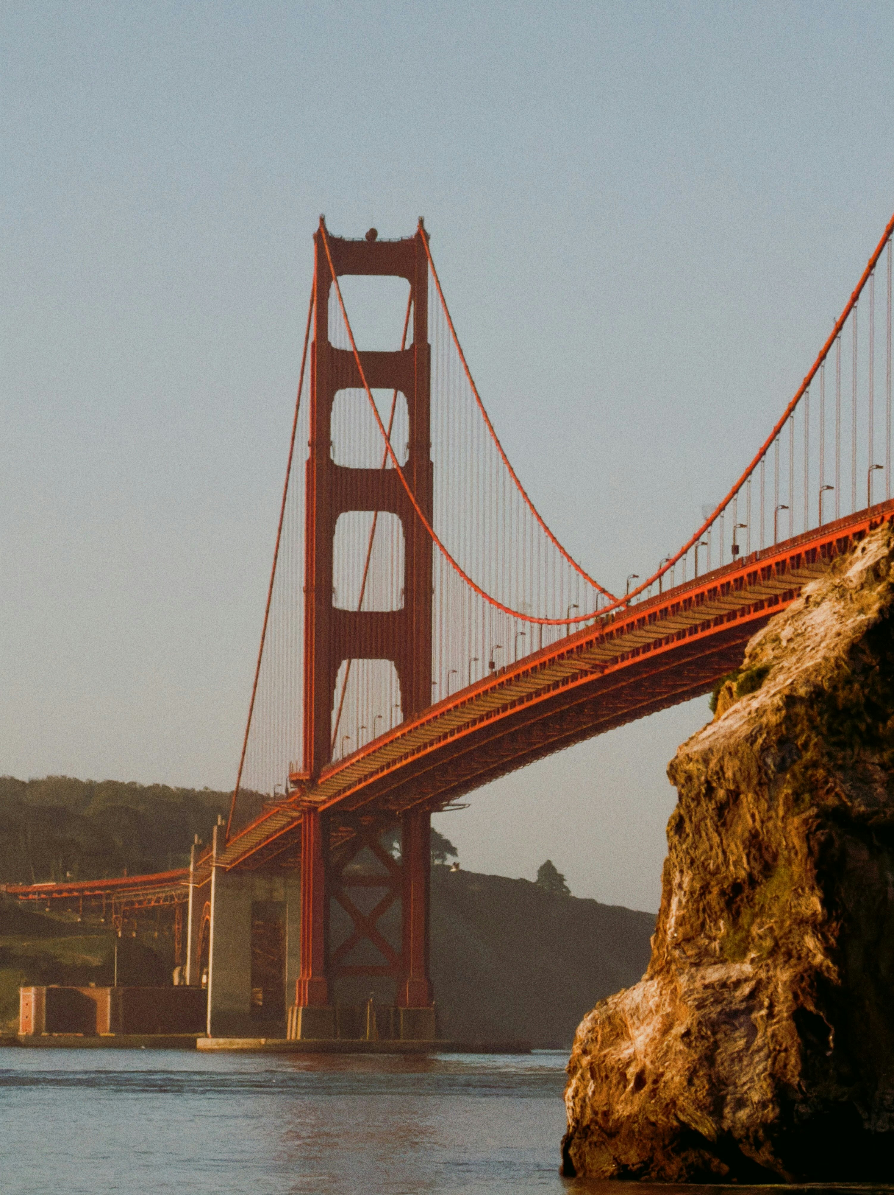 The golden gate bridge spans across the water.