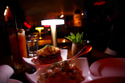 Appetizers and drinks on a dimly lit table
