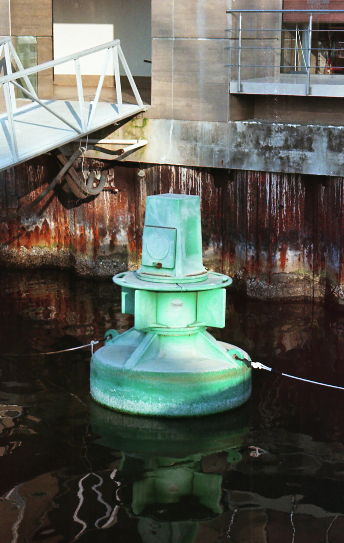 Navigation aid in a marine basin with a steel sheet-pile quay wall — the kind of pier, pile, and channel-marker structure Texas Tuff Rock Bags armor against current scour