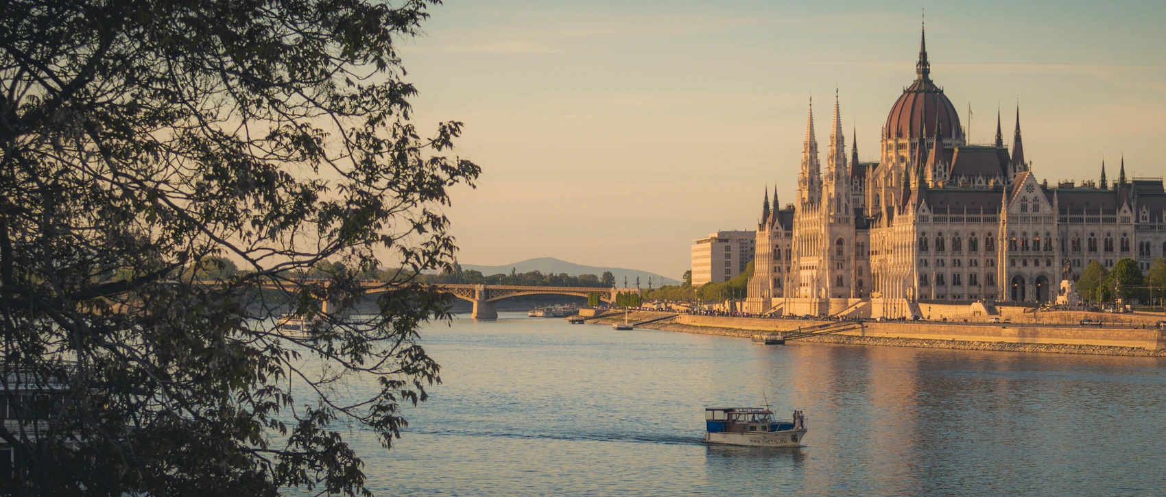 A boat cruising along the Danube past the Hungarian Parliament at sunset