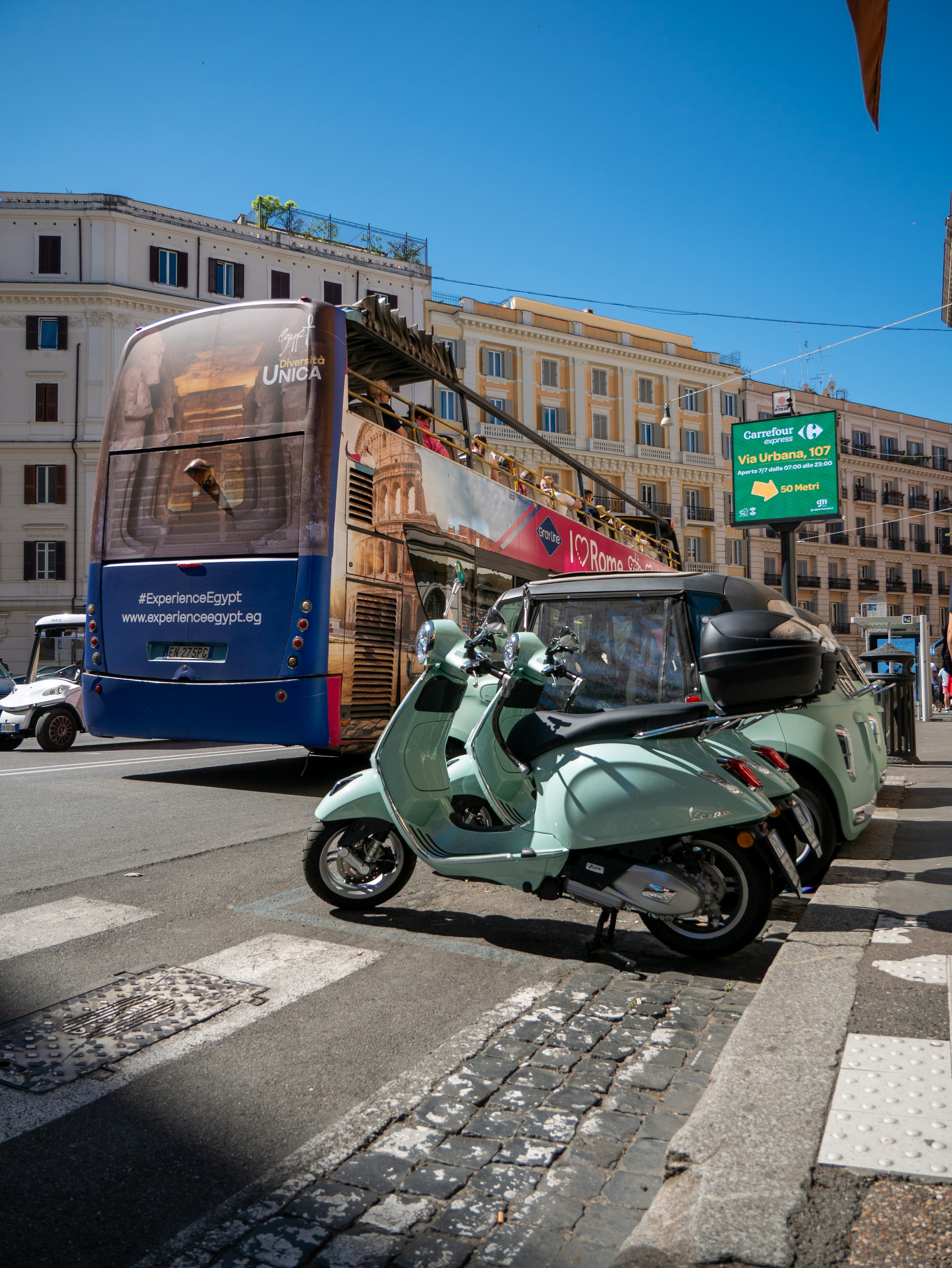 A mint green scooter parked on a city street