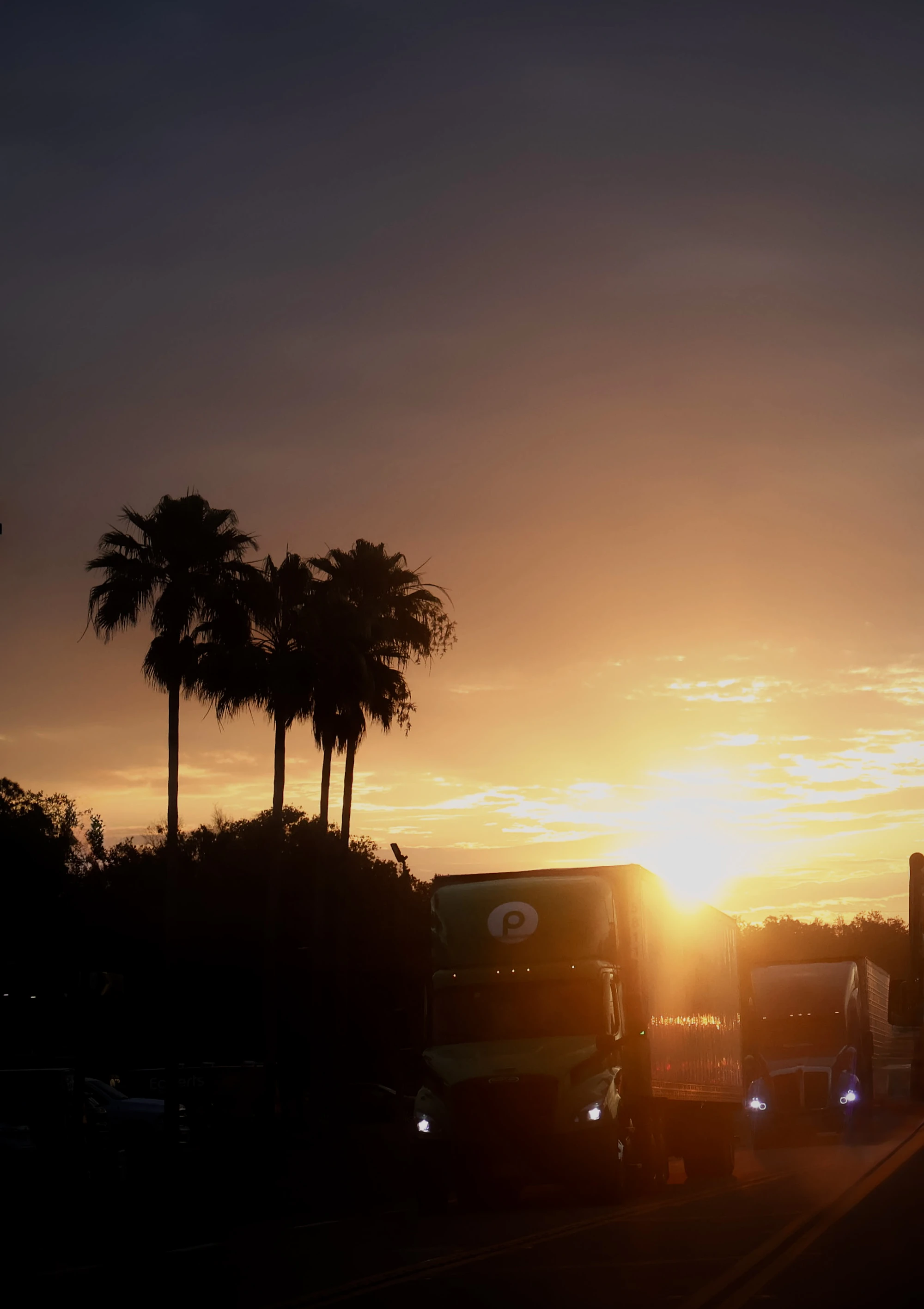 Trucks driving at sunset