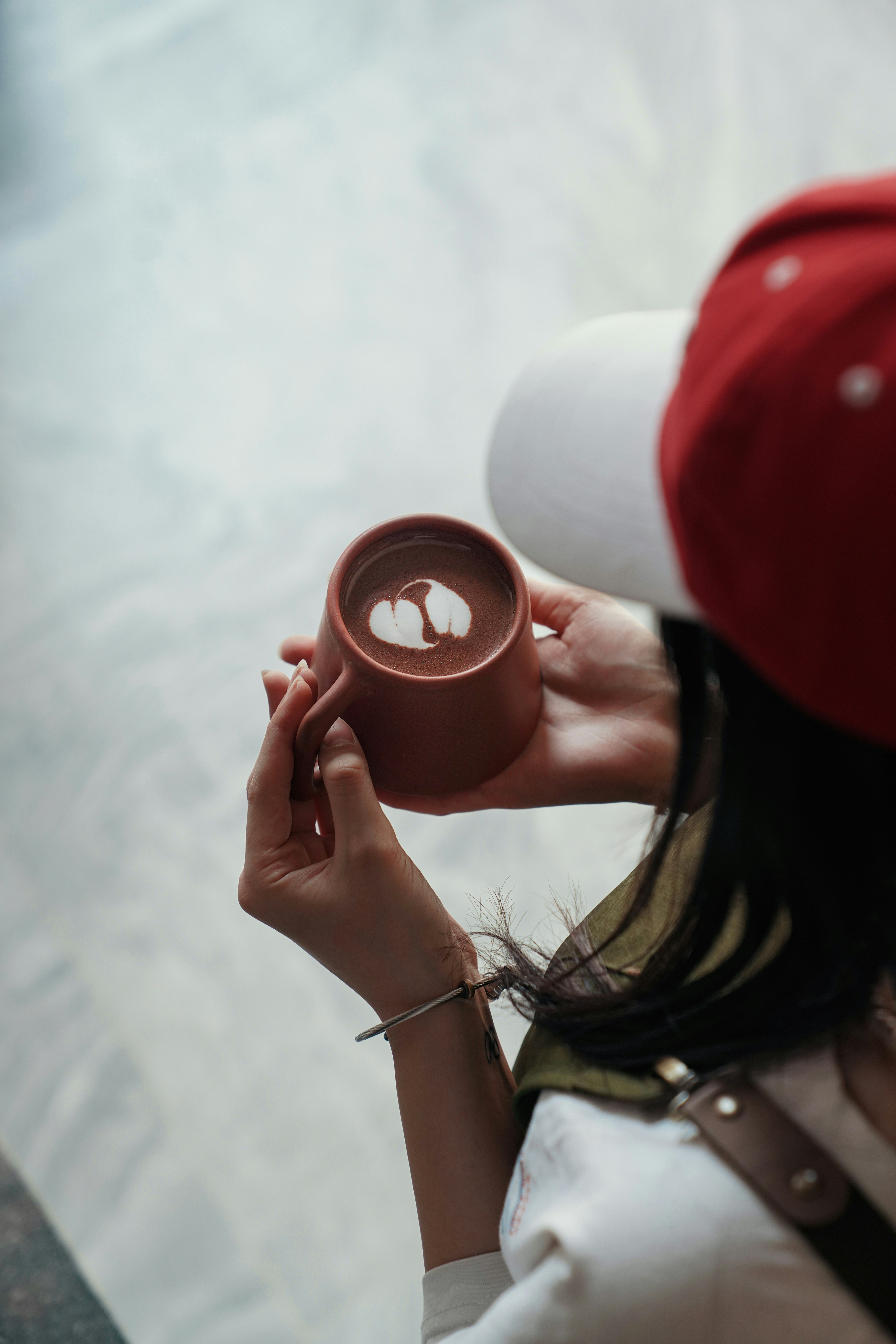Person holding a mug with latte art