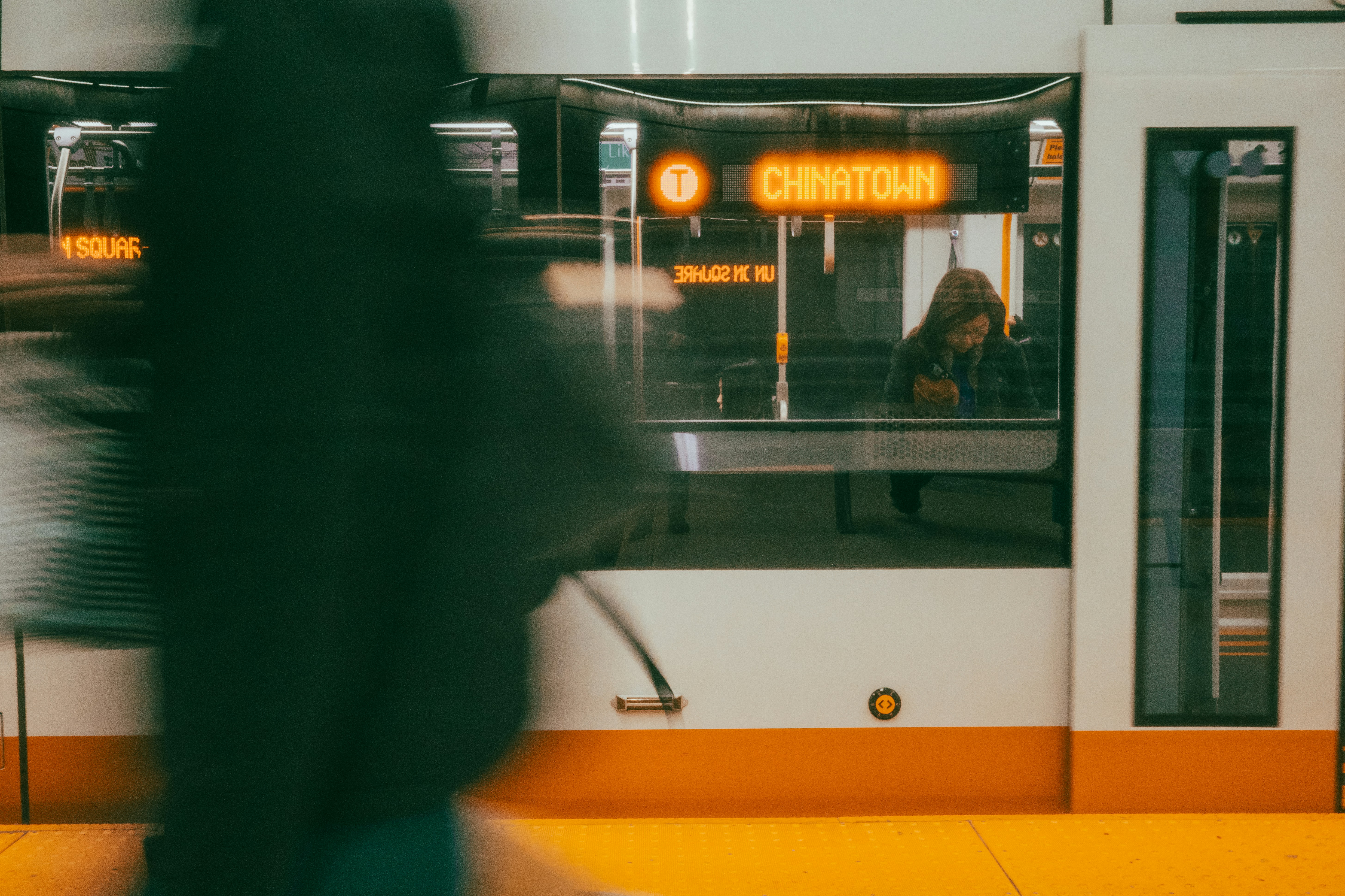 Die Leute gehen an einem Bahnhof an einem Zug vorbei.
