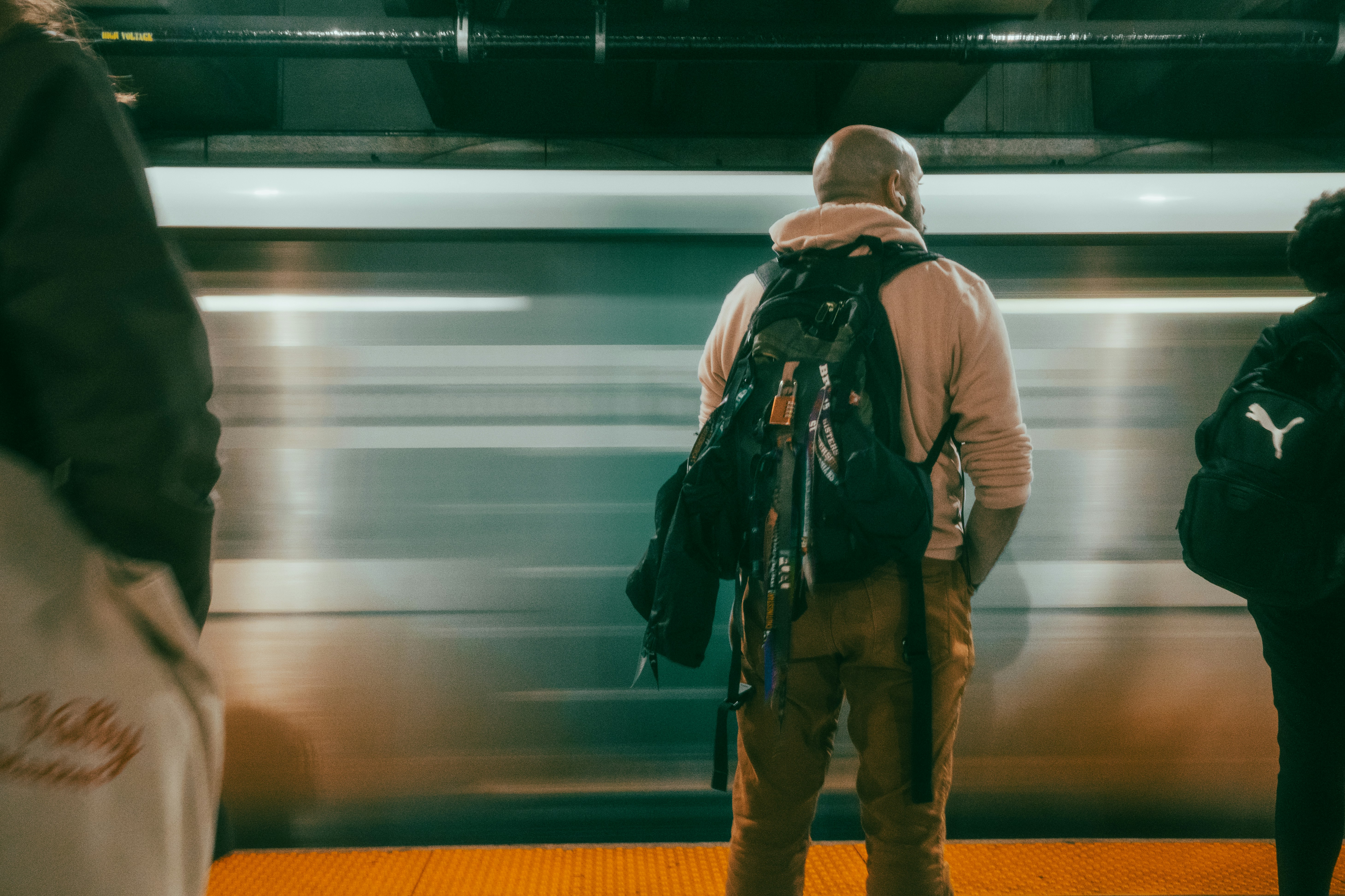 Menschen, die an einem Bahnhof auf einen Zug warten