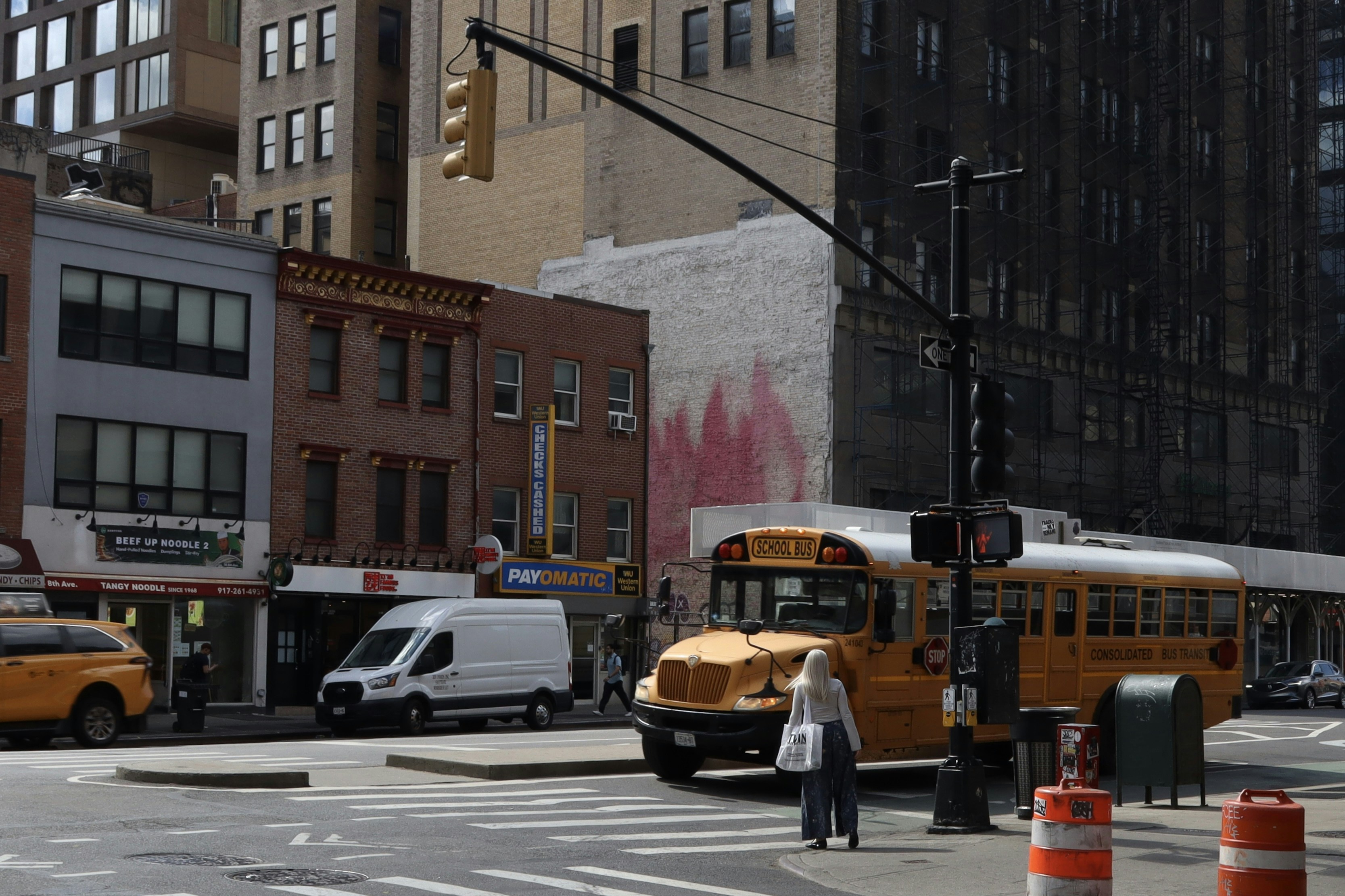 Yellow school bus on a city street corner.