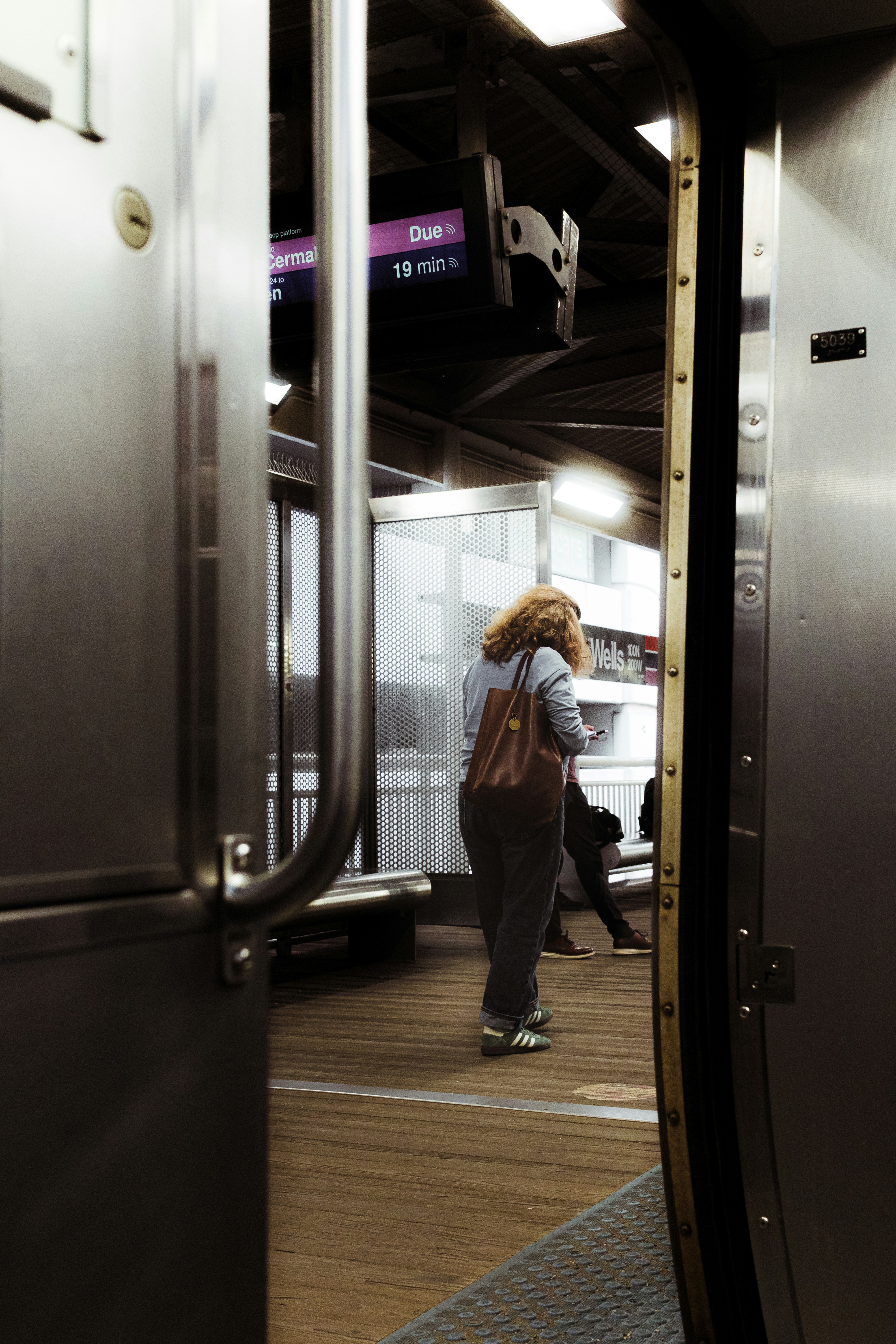 Frau steht auf einem Bahnsteig und wartet