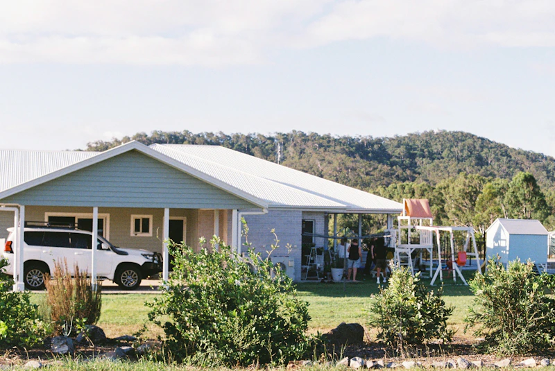 Suburban home with green lawn and landscaping, representing full-home pest and lawn protection