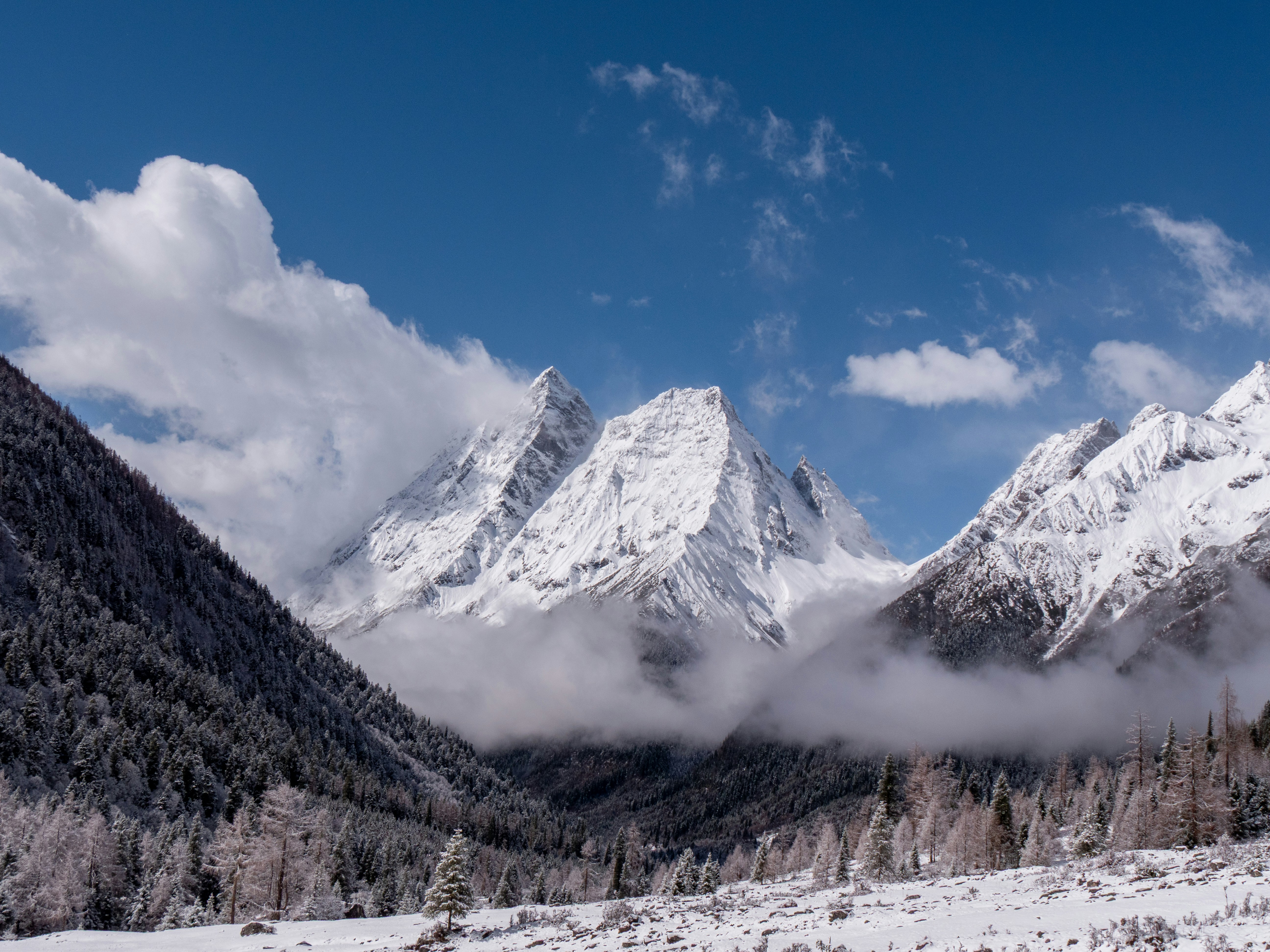 Montagne coperte di neve sotto un cielo azzurro con nuvole