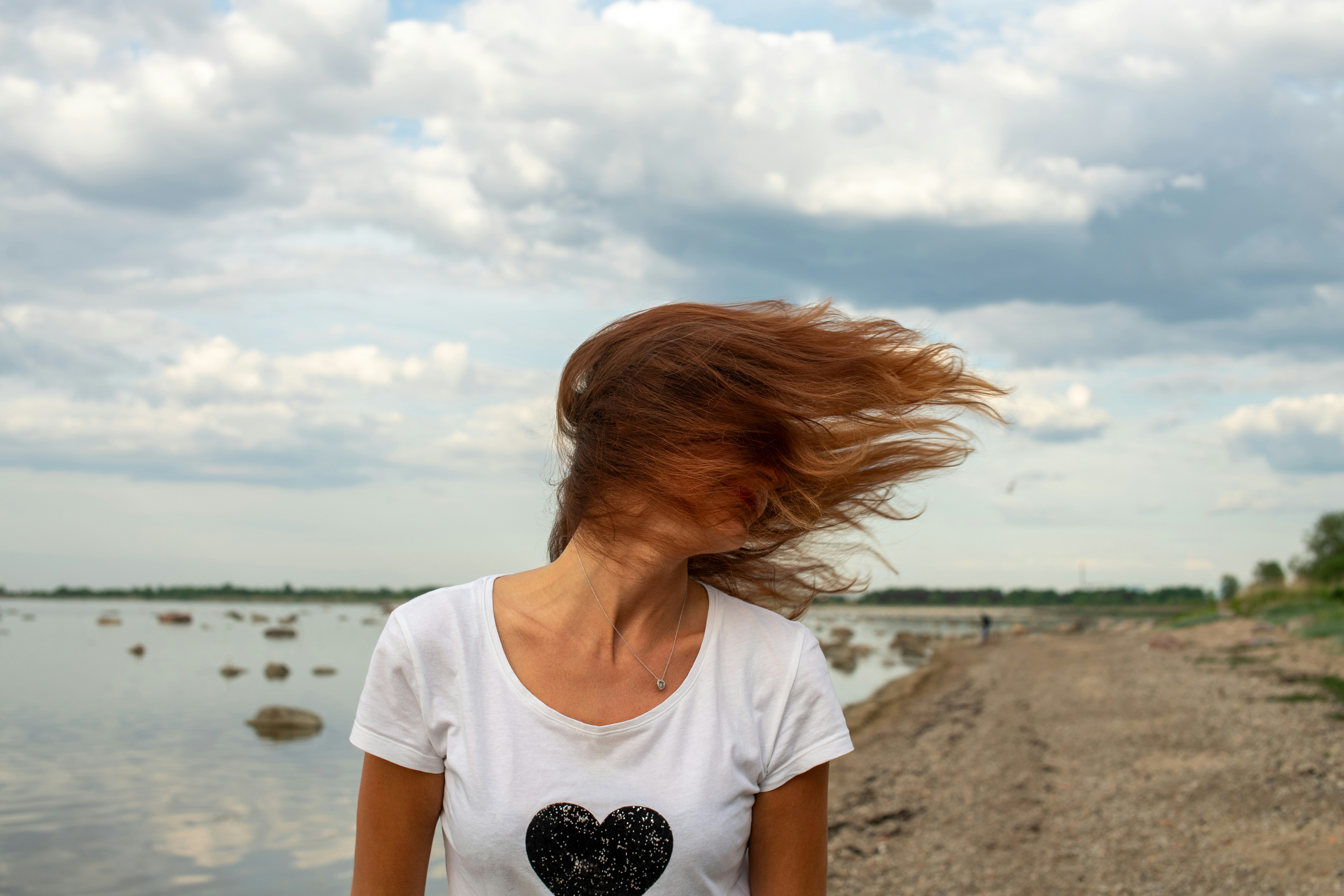 Windblown hair by the water, showing humidity-related frizz