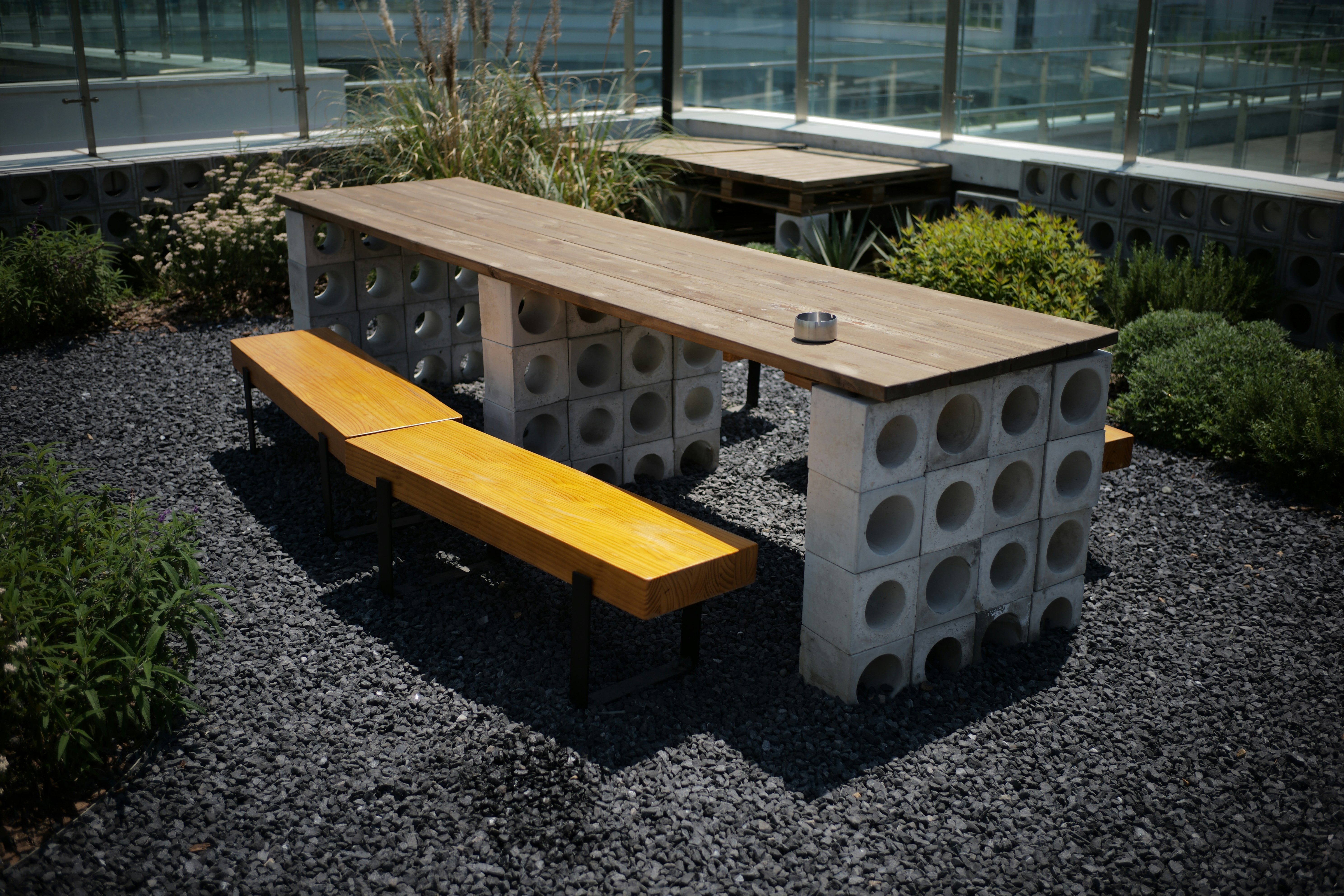 Outdoor picnic table with concrete block base and wooden benches