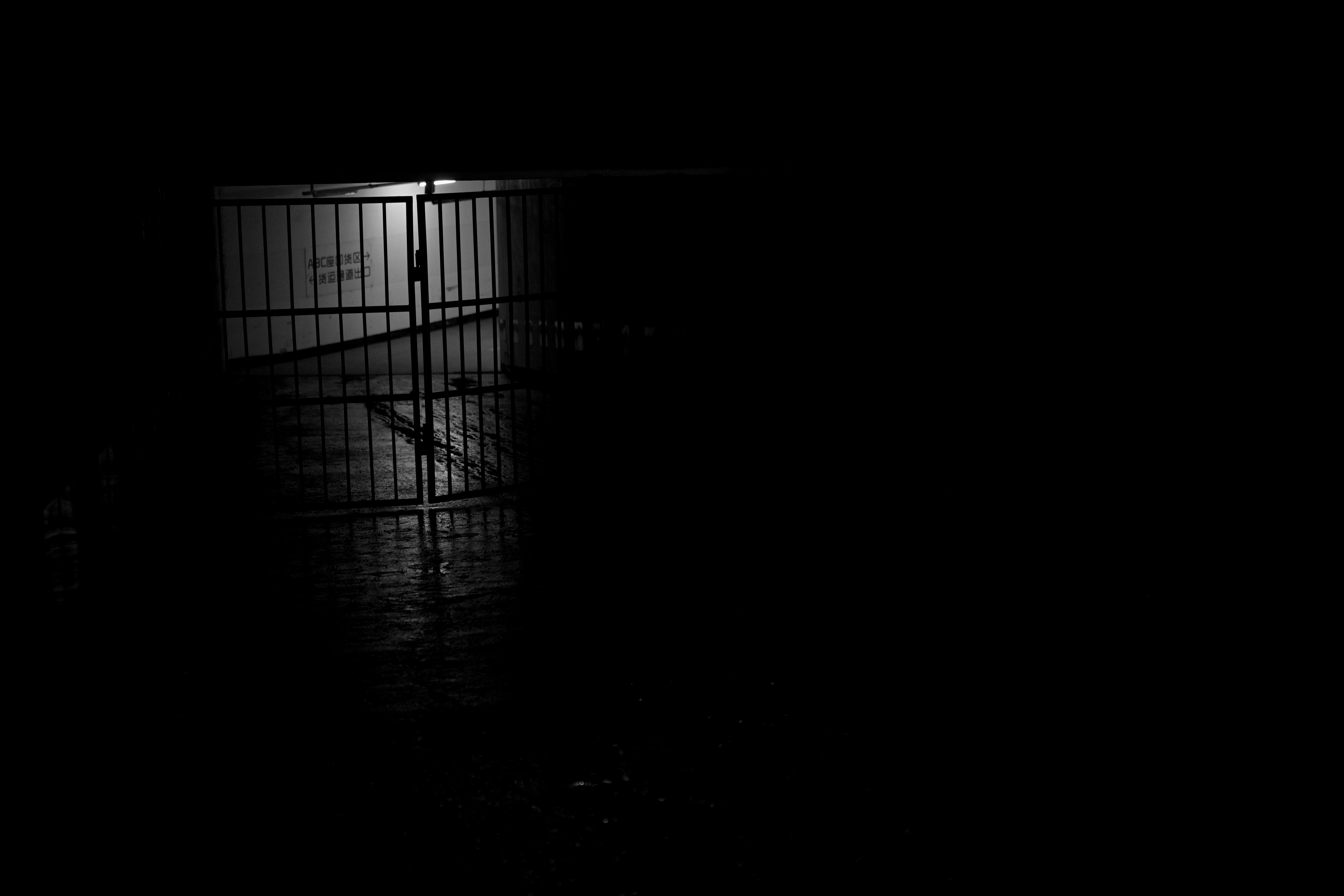A metal barrel sits on a wet surface at night.