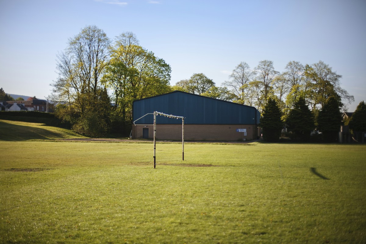 A soccer goal on a grassy field, ideal for end of school year events and planning outdoor activities.