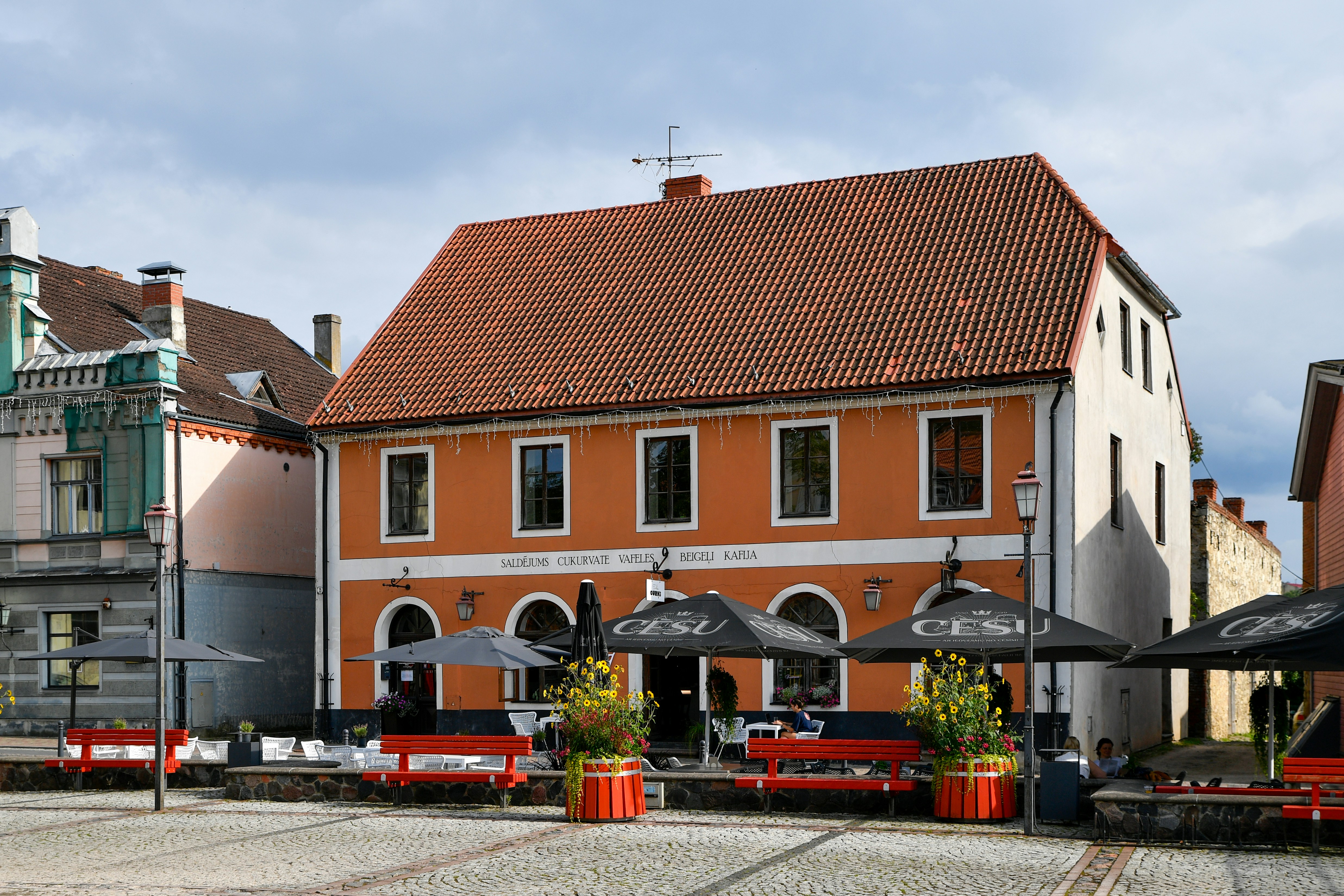 Orange building with outdoor seating in front