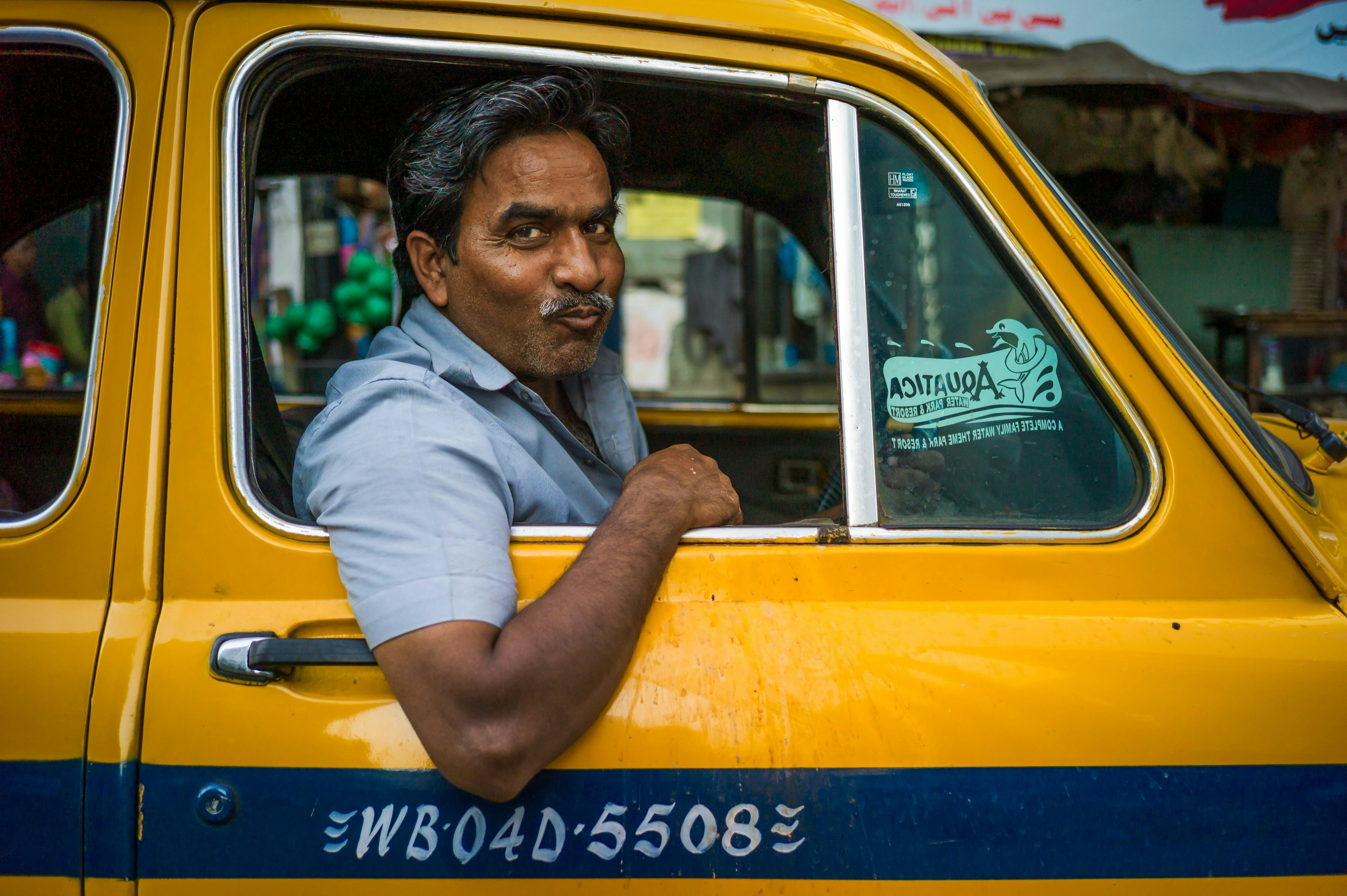 Man driving a yellow taxi cab