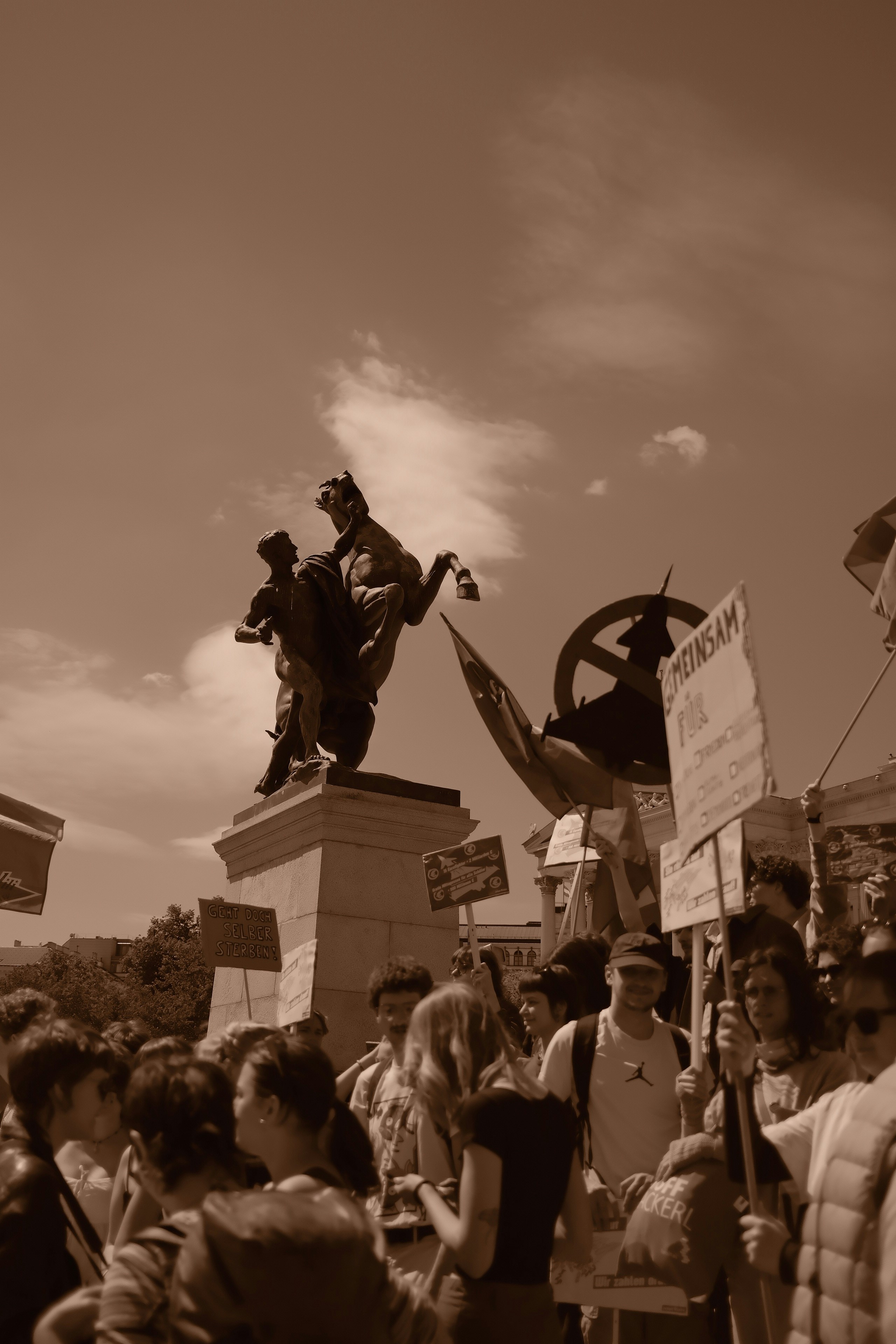 La multitud se reunió cerca de una estatua con pancartas de protesta