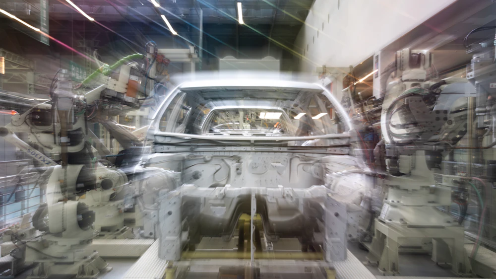 Automotive assembly line with robotic arms and car body