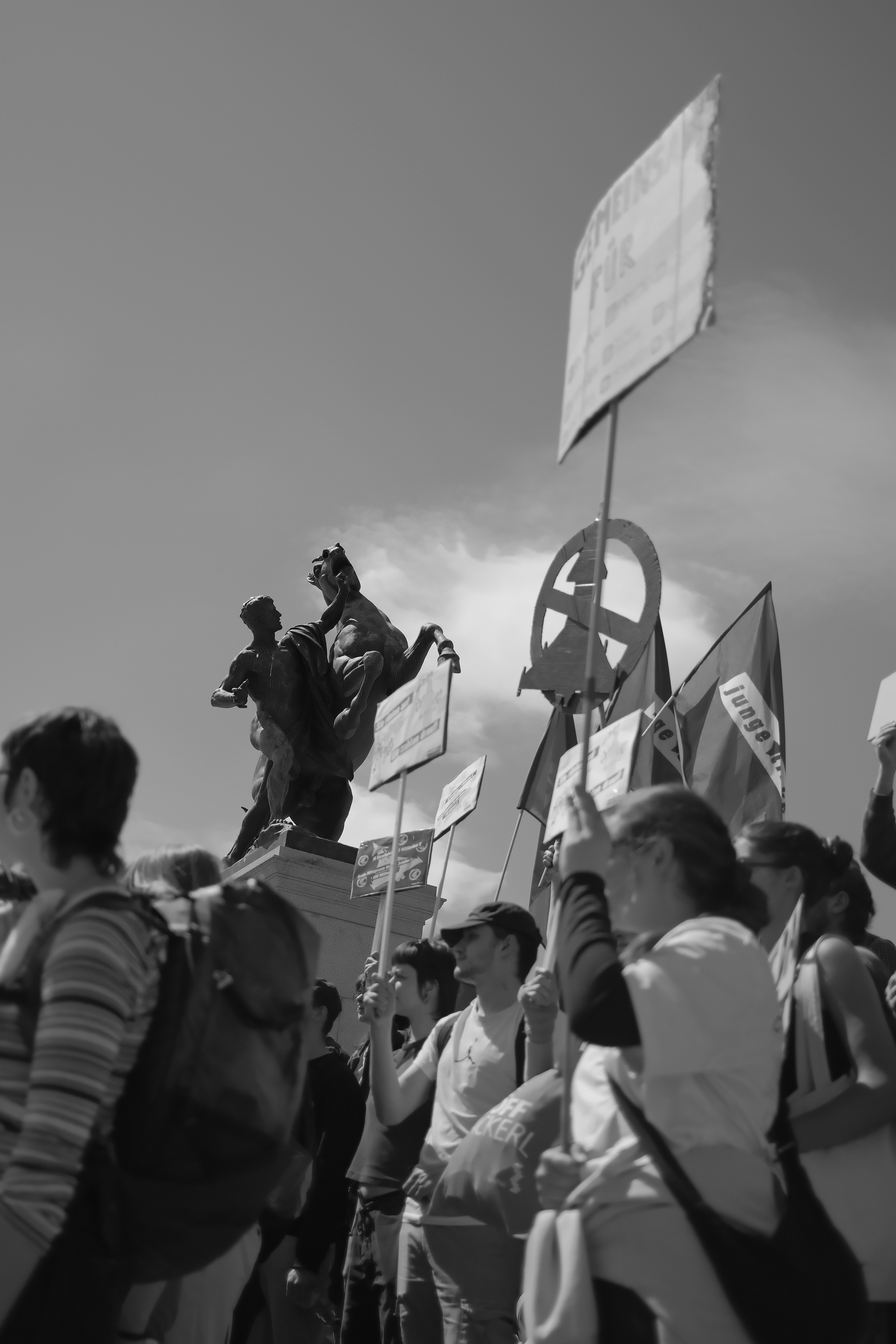 Menschen, die Schilder und Fahnen bei einer Protestkundgebung halten.